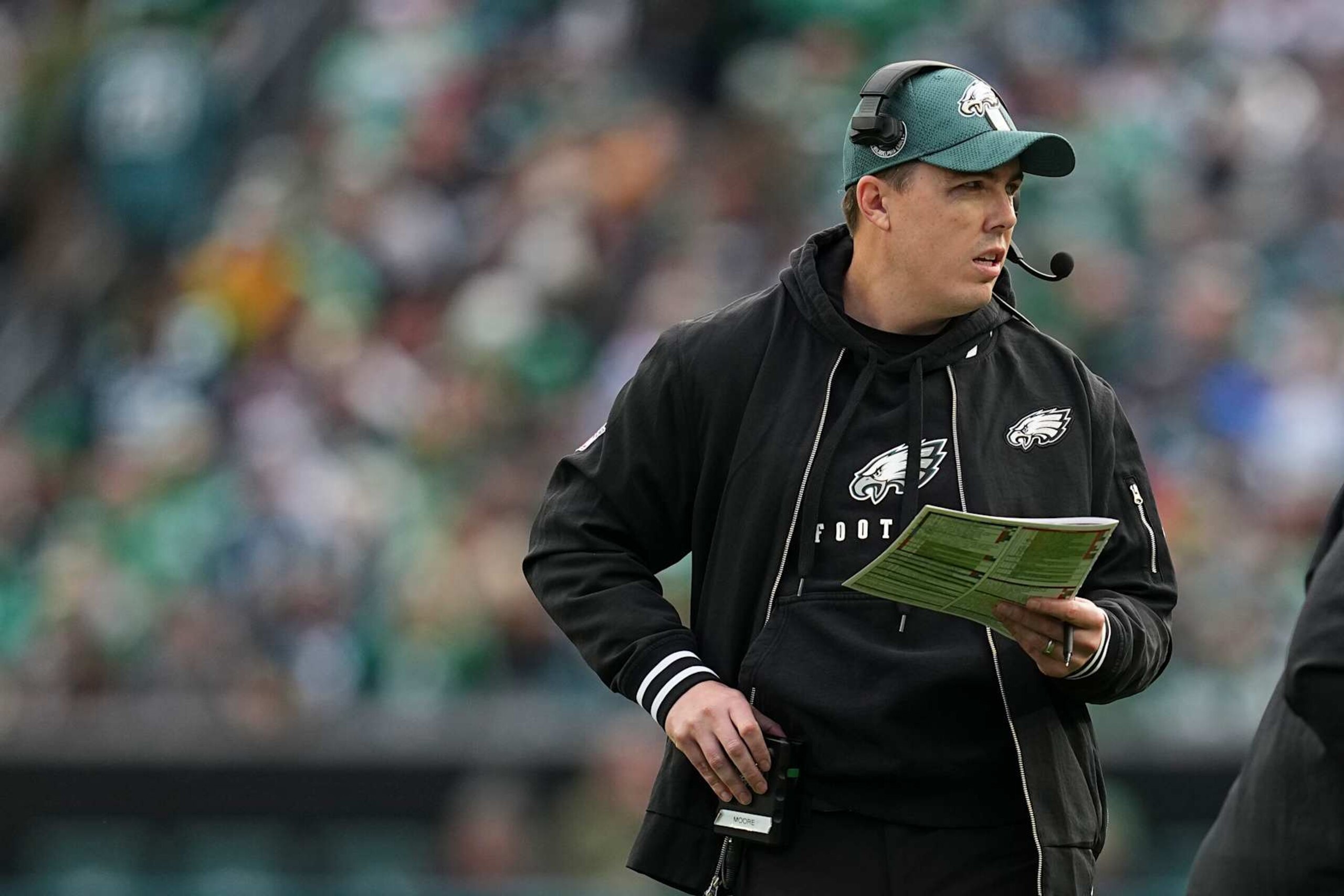 PHILADELPHIA, PENNSYLVANIA - DECEMBER 8: Offensive coordinator Kellen Moore of the Philadelphia Eagles looks on against the Carolina Panthers at Lincoln Financial Field on December 8, 2024 in Philadelphia, Pennsylvania. (Photo by Mitchell Leff/Getty Images) PHILADELPHIA, PENNSYLVANIA - DECEMBER 8: Offensive coordinator Kellen Moore of the Philadelphia Eagles looks on against the Carolina Panthers at Lincoln Financial Field on December 8, 2024 in Philadelphia, Pennsylvania. (Photo by Mitchell Leff/Getty Images)