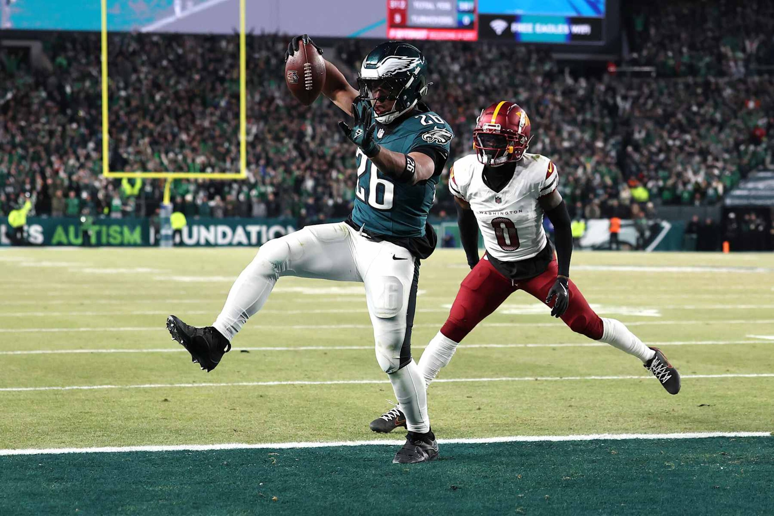 PHILADELPHIA, PENNSYLVANIA - JANUARY 26: Saquon Barkley #26 of the Philadelphia Eagles scores a touchdown against Mike Sainristil #0 of the Washington Commanders during the fourth quarter in the NFC Championship Game at Lincoln Financial Field on January 26, 2025 in Philadelphia, Pennsylvania.  (Photo by Emilee Chinn/Getty Images)