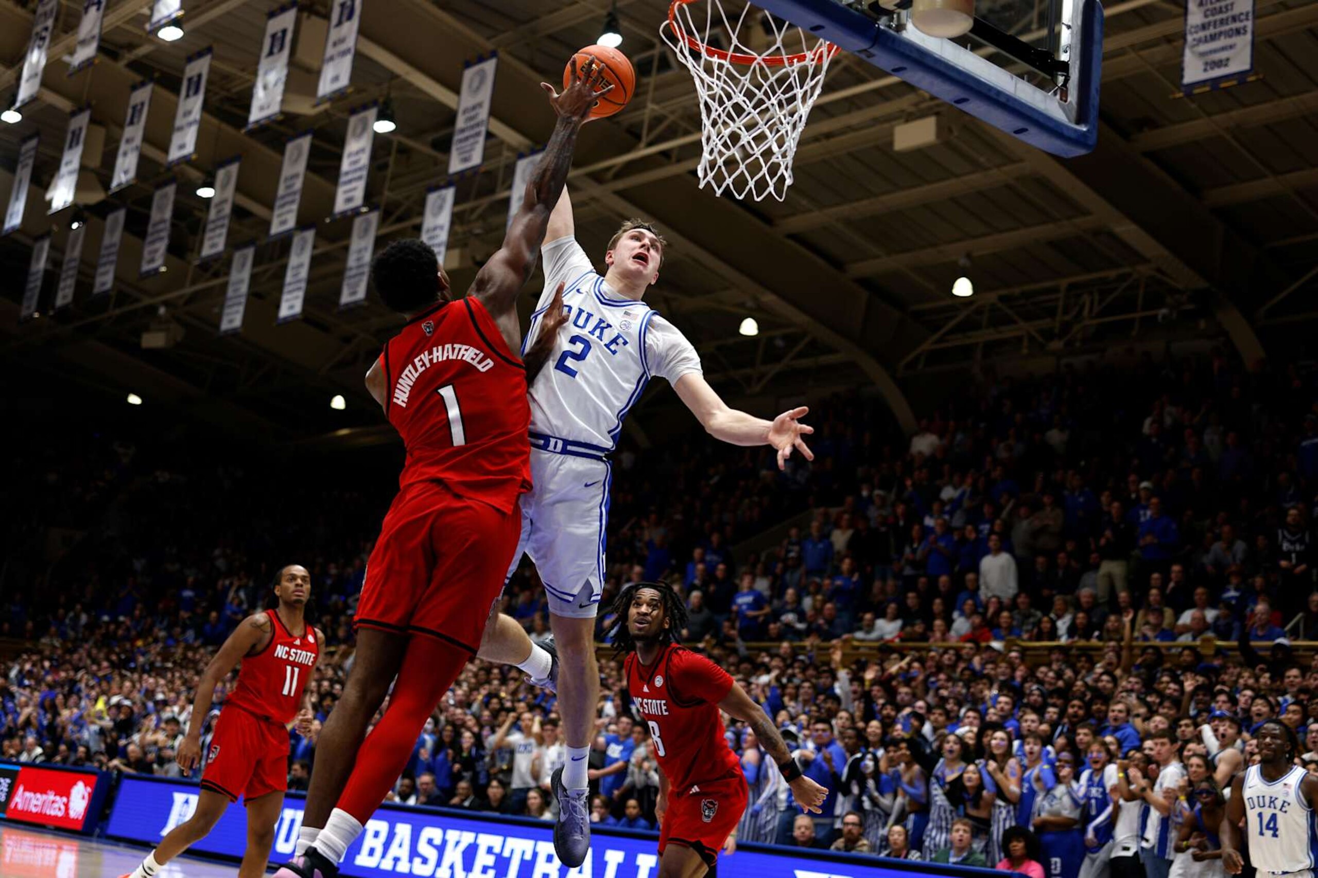 DURHAM, NORTH CAROLINA - JANUARY 27: Cooper Flagg #2 of the Duke Blue Devils is fouled by Brandon Huntley-Hatfield #1 of the NC State Wolfpack during a dunk attempt in the first half at Cameron Indoor Stadium on January 27, 2025 in Durham, North Carolina. (Photo by Lance King/Getty Images) DURHAM, NORTH CAROLINA - JANUARY 27: Cooper Flagg #2 of the Duke Blue Devils is fouled by Brandon Huntley-Hatfield #1 of the NC State Wolfpack during a dunk attempt in the first half at Cameron Indoor Stadium on January 27, 2025 in Durham, North Carolina. (Photo by Lance King/Getty Images)