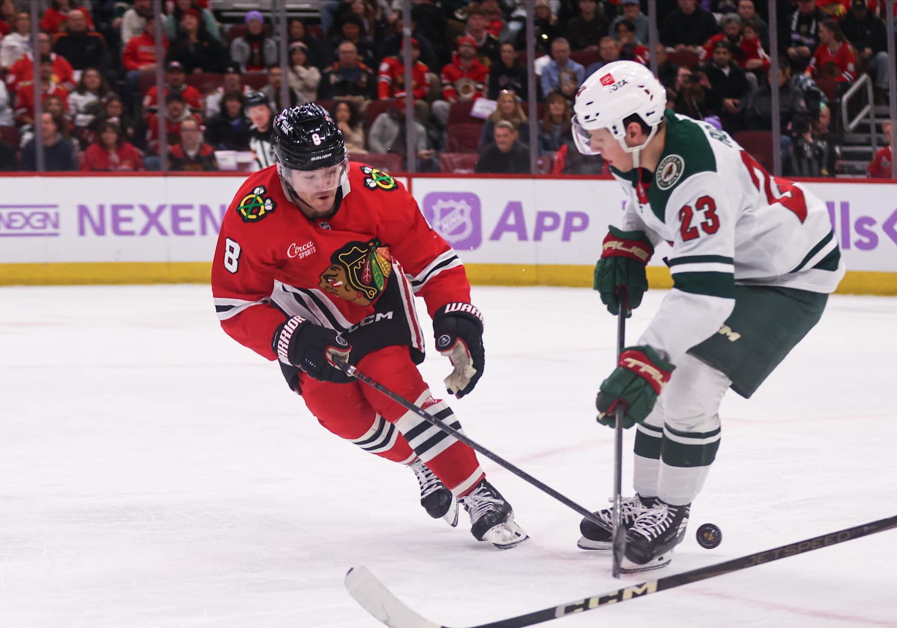 CHICAGO, IL - JANUARY 26: Ryan Donato #8 of the Chicago Blackhawks poke checks the puck from Marco Rossi #23 of the Minnesota Wild during the third period on January 26, 2025 at the United Center in Chicago, Illinois. (Photo by Melissa Tamez/Icon Sportswire via Getty Images)