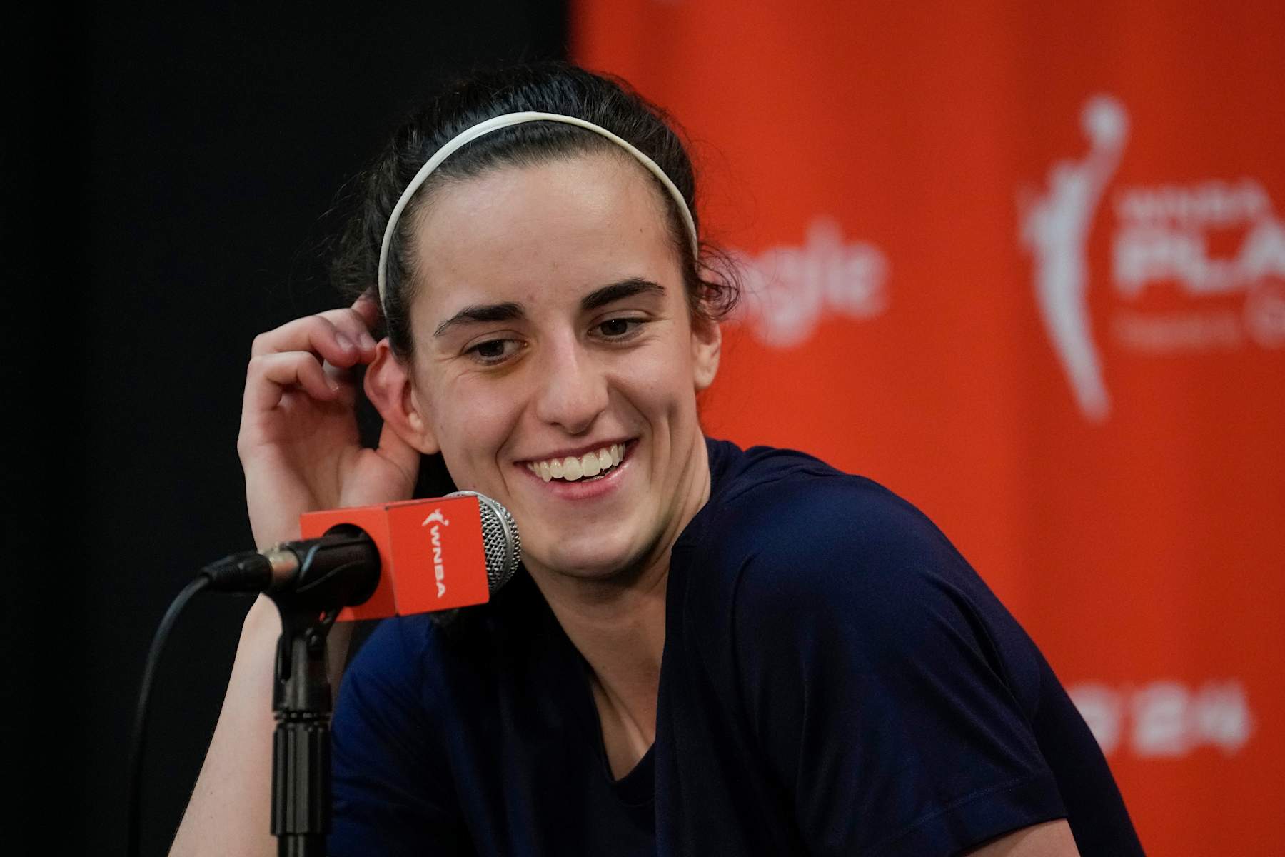 UNCASVILLE, CONNECTICUT - SEPTEMBER 25: Caitlin Clark #22 of the Indiana Fever smiles during a press conference after losing 81-87 to the Connecticut Sun in Game Two of the 2024 WNBA Playoffs first round at Mohegan Sun Arena on September 25, 2024 in Uncasville, Connecticut. (Photo by Joe Buglewicz/Getty Images) UNCASVILLE, CONNECTICUT - SEPTEMBER 25: Caitlin Clark #22 of the Indiana Fever smiles during a press conference after losing 81-87 to the Connecticut Sun in Game Two of the 2024 WNBA Playoffs first round at Mohegan Sun Arena on September 25, 2024 in Uncasville, Connecticut. (Photo by Joe Buglewicz/Getty Images)