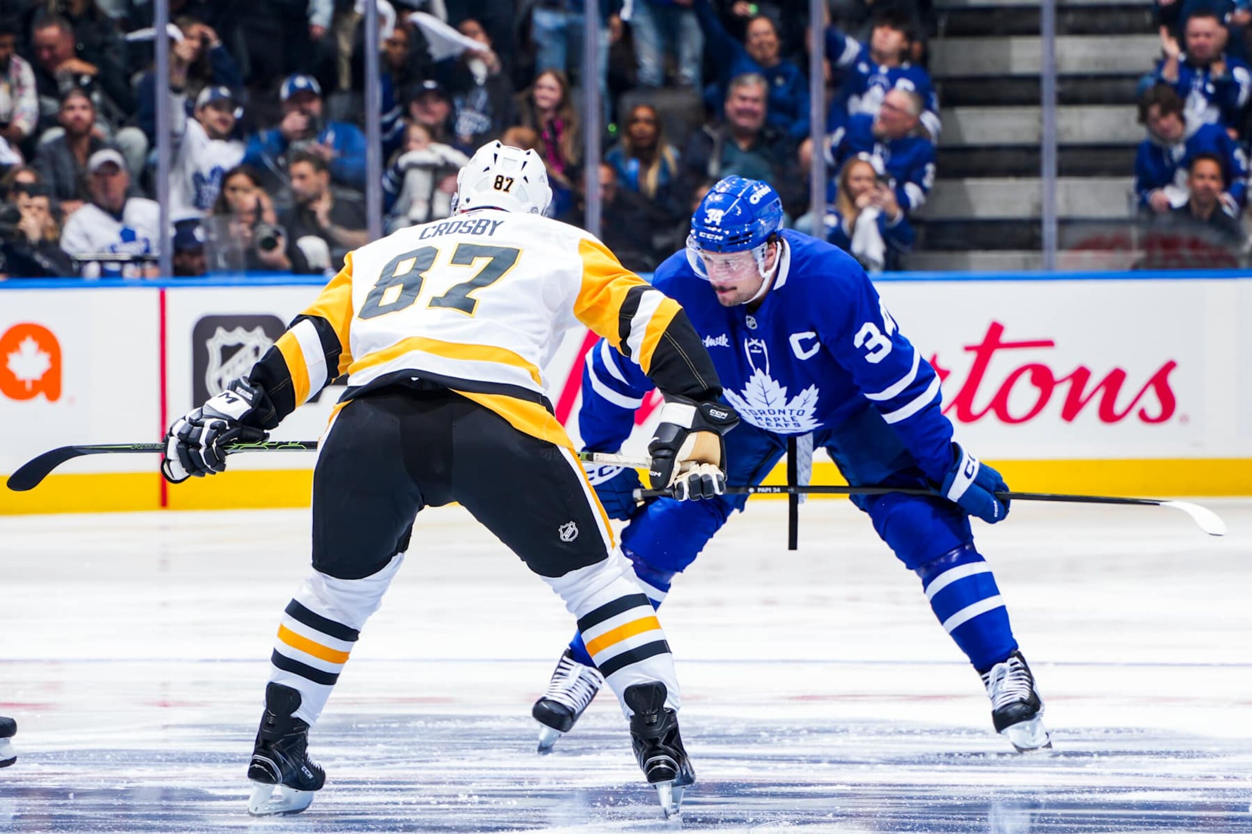 TORONTO, ONTARIO - OCTOBER 12: Auston Matthews #34 of the Toronto Maple and Sidney Crosby #87 of the Pittsburgh Penguins during the opening face-off of the Toronto Maple Leafs Home Opener at the Scotiabank Arena on October 12, 2024 in Toronto, Ontario, Canada. (Photo by Mark Blinch/NHLI via Getty Images) TORONTO, ONTARIO - OCTOBER 12: Auston Matthews #34 of the Toronto Maple and Sidney Crosby #87 of the Pittsburgh Penguins during the opening face-off of the Toronto Maple Leafs Home Opener at the Scotiabank Arena on October 12, 2024 in Toronto, Ontario, Canada. (Photo by Mark Blinch/NHLI via Getty Images)