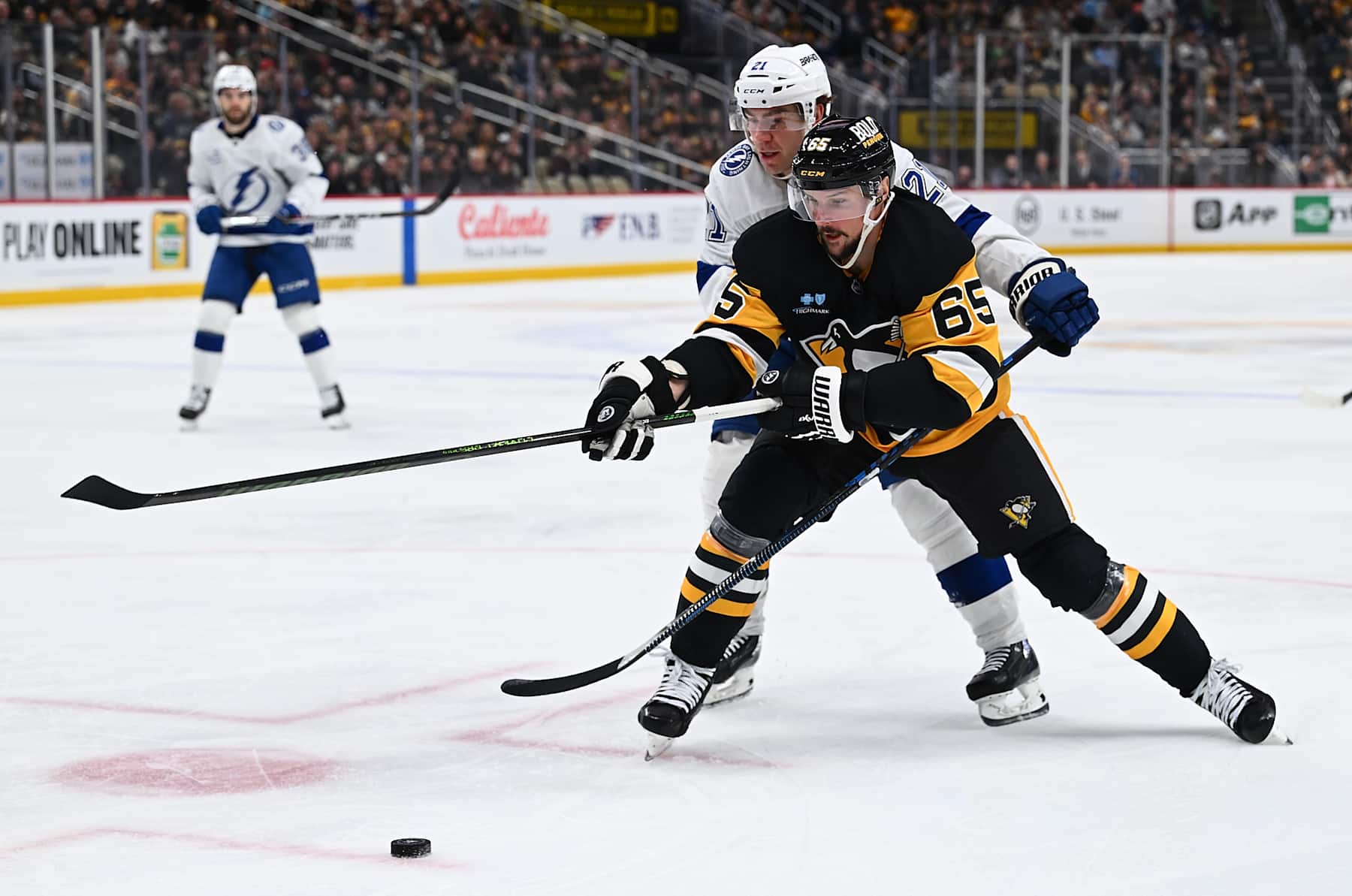 PITTSBURGH, PENNSYLVANIA - JANUARY 12: Erik Karlsson #65 of the Pittsburgh Penguins skates with the puck against Brayden Point #21 of the Tampa Bay Lightning in the third period at PPG PAINTS Arena on January 12, 2025 in Pittsburgh, Pennsylvania. (Photo by Justin Berl/Getty Images)