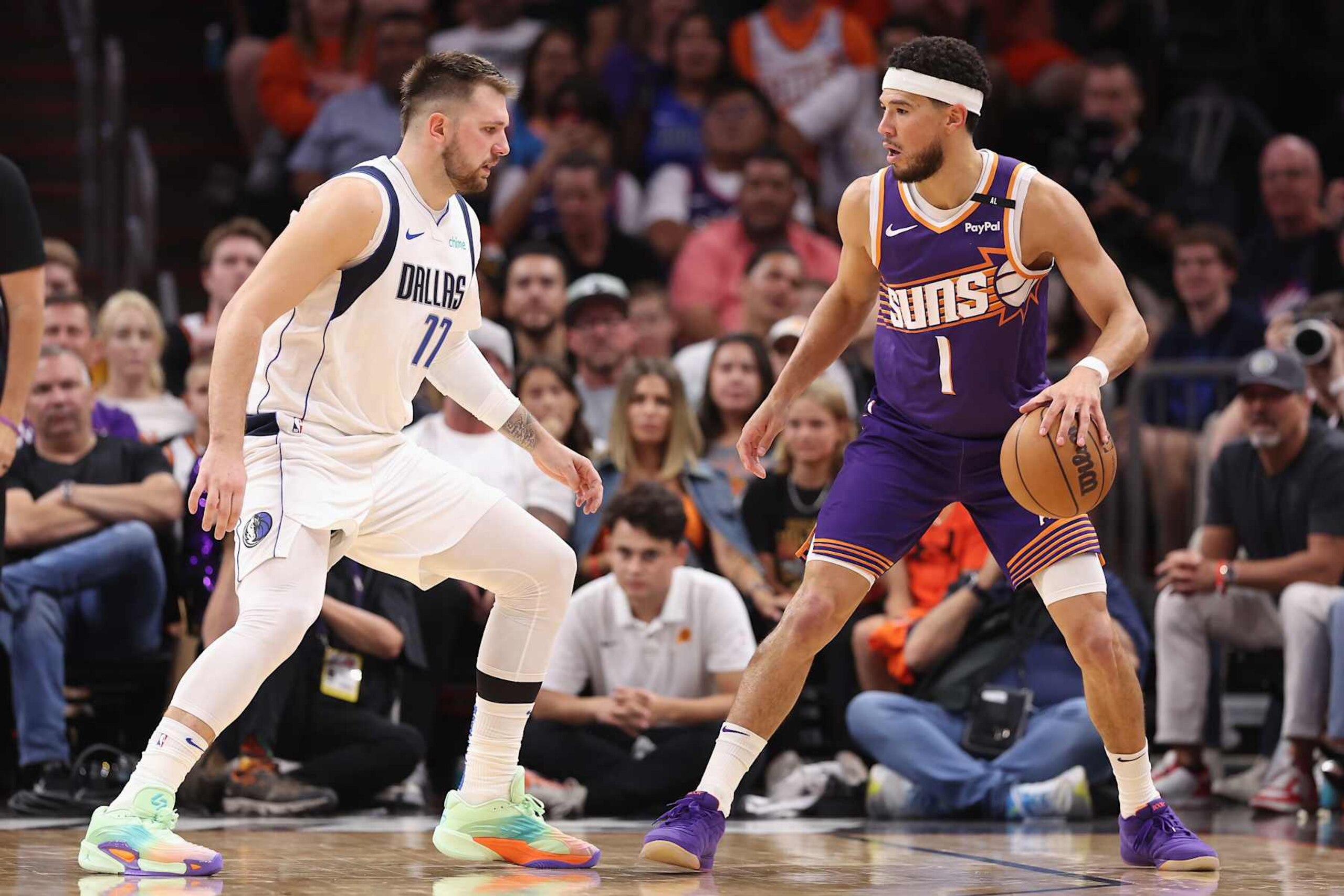 PHOENIX, ARIZONA - OCTOBER 26: Devin Booker #1 of the Phoenix Suns handles the ball against Luka Doncic #77 of the Dallas Mavericks during the NBA game at Footprint Center on October 26, 2024 in Phoenix, Arizona. The Suns defeated the Mavericks 114-102.  NOTE TO USER: User expressly acknowledges and agrees that, by downloading and/or using this photograph, user is consenting to the terms and conditions of the Getty Images License Agreement. (Photo by Christian Petersen/Getty Images)