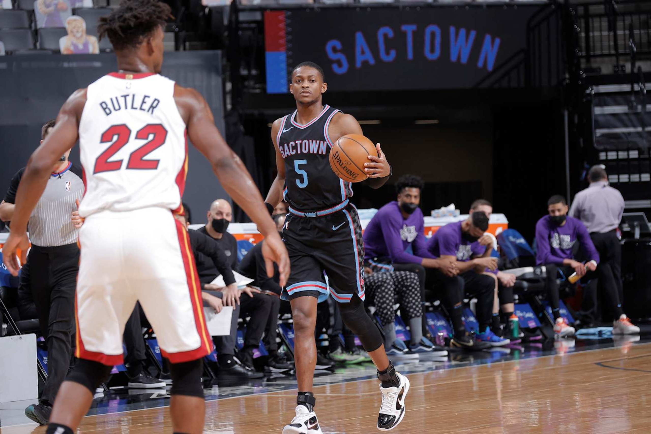 SACRAMENTO, CA - FEBRUARY 18: De'Aaron Fox #5 of the Sacramento Kings brings the ball up the court against Jimmy Butler #22 of the Miami Heat on February 18, 2021 at Golden 1 Center in Sacramento, California. NOTE TO USER: User expressly acknowledges and agrees that, by downloading and or using this photograph, User is consenting to the terms and conditions of the Getty Images Agreement. Mandatory Copyright Notice: Copyright 2021 NBAE (Photo by Rocky Widner/NBAE via Getty Images)
