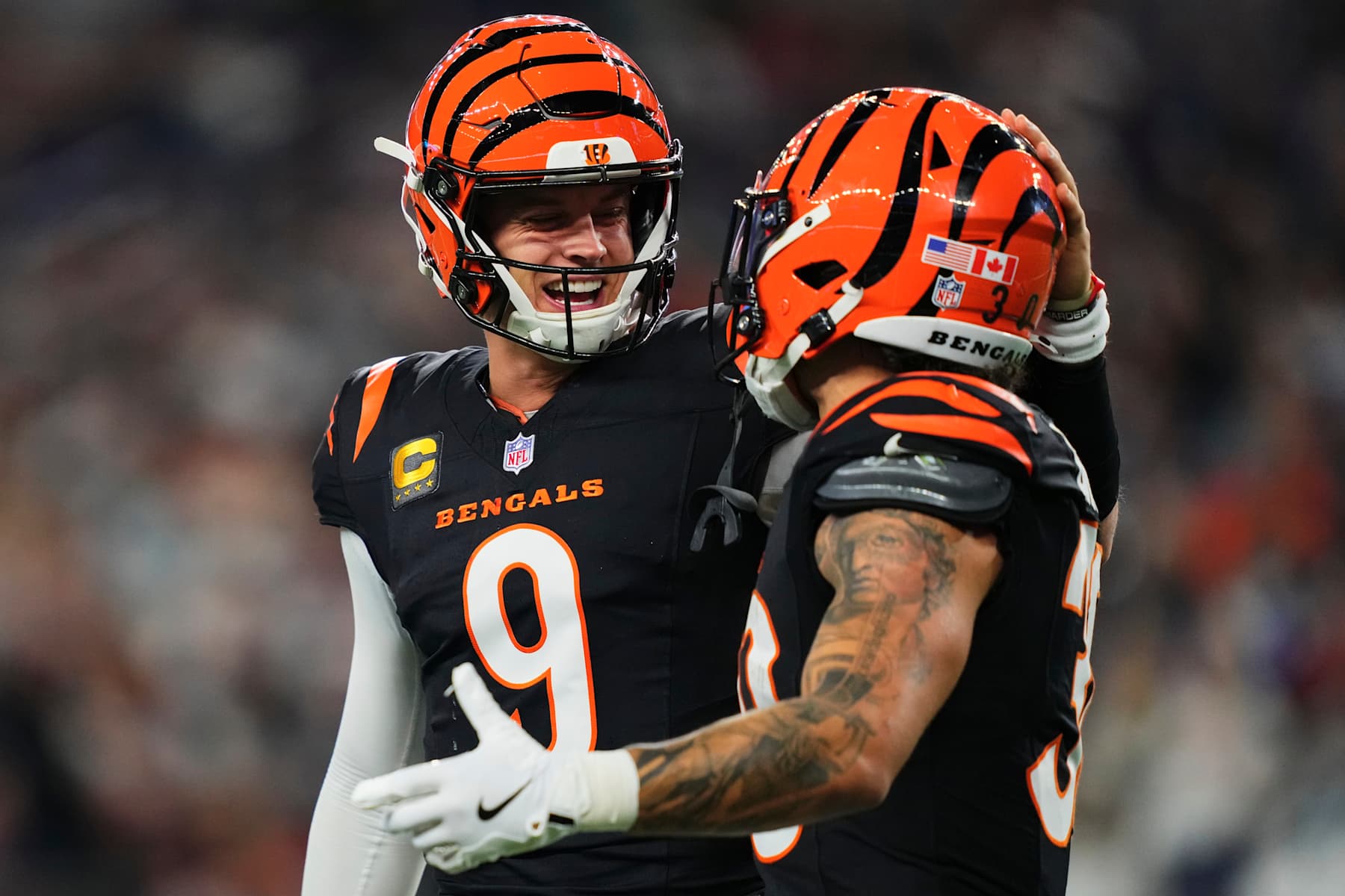 ARLINGTON, TX - DECEMBER 09: Joe Burrow #9 of the Cincinnati Bengals celebrates after scoring a touchdown with teammate Cincinnati Bengals running back Chase Brown (30) against the Dallas Cowboys during the first half of an NFL football game at AT&T Stadium on December 9, 2024 in Arlington, Texas. (Photo by Cooper Neill/Getty Images)