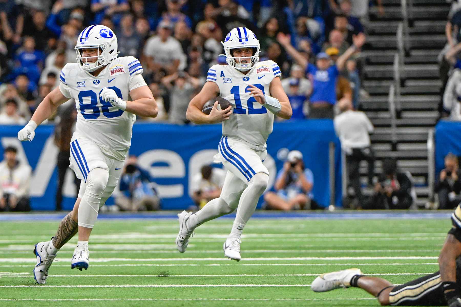 SAN ANTONIO, TX - DECEMBER 28: Brigham Young Cougars quarterback Jake Retzlaff (12) rushes to the outside as Brigham Young Cougars tight end Mata'ava Ta'ase (88) looks to block during the football game between the BYU Cougars and Colorado Buffaloes on December 28, 2024, at the Alamodome in San Antonio, Texas. (Photo by Ken Murray/Icon Sportswire via Getty Images)