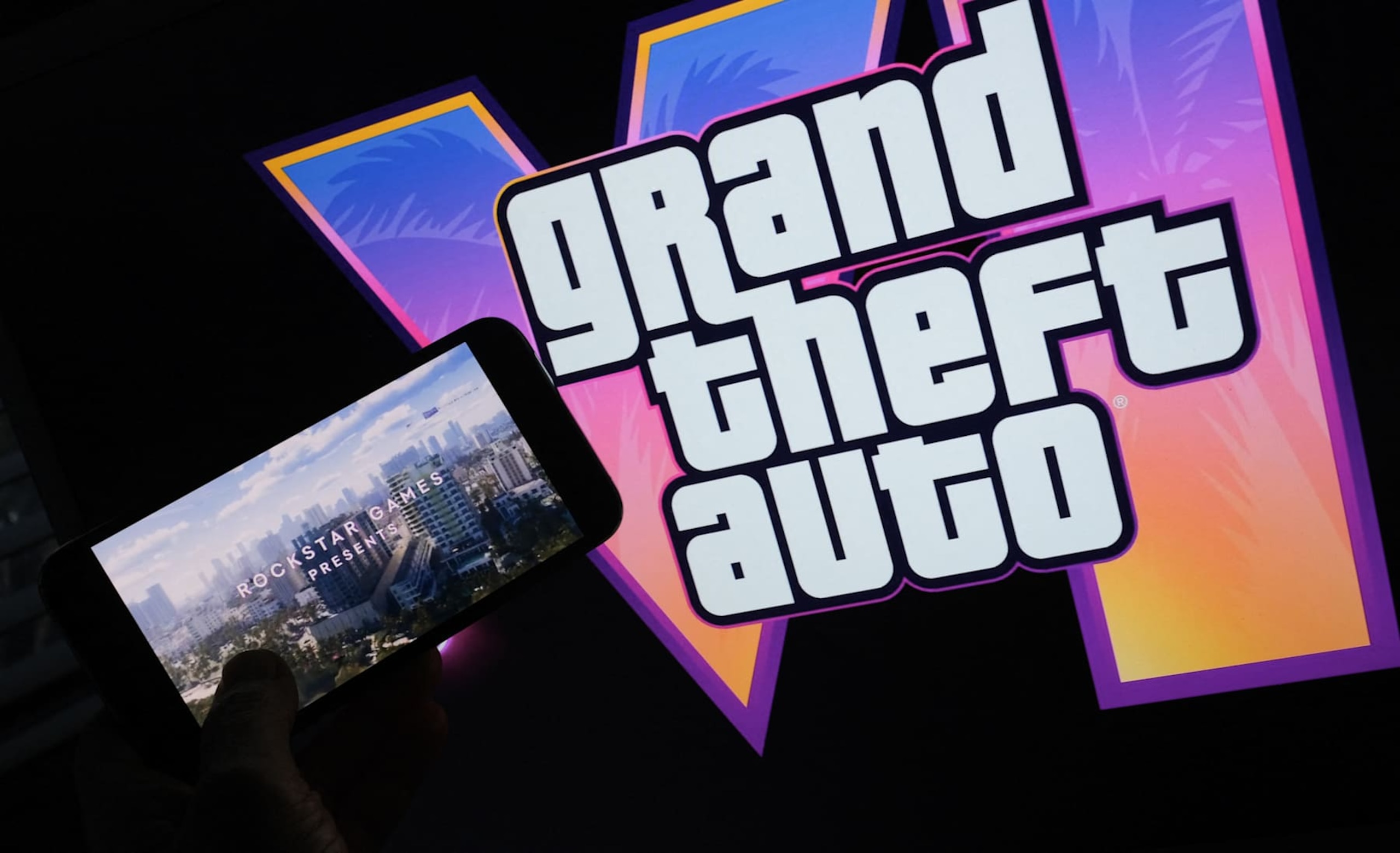 This illustration photo created in Los Angeles, December 4, 2023, shows Rockstar Games' Grand Theft Auto VI trailer played on a screen in front of the game title. The first trailer for "Grand Theft Auto VI" was officially released ahead of schedule December 4, 2023 due to a leak, touting a 2025 release for the next chapter of the massively successful video game franchise. (Photo by Chris DELMAS / AFP) (Photo by CHRIS DELMAS/AFP via Getty Images) This illustration photo created in Los Angeles, December 4, 2023, shows Rockstar Games' Grand Theft Auto VI trailer played on a screen in front of the game title. The first trailer for "Grand Theft Auto VI" was officially released ahead of schedule December 4, 2023 due to a leak, touting a 2025 release for the next chapter of the massively successful video game franchise. (Photo by Chris DELMAS / AFP) (Photo by CHRIS DELMAS/AFP via Getty Images)
