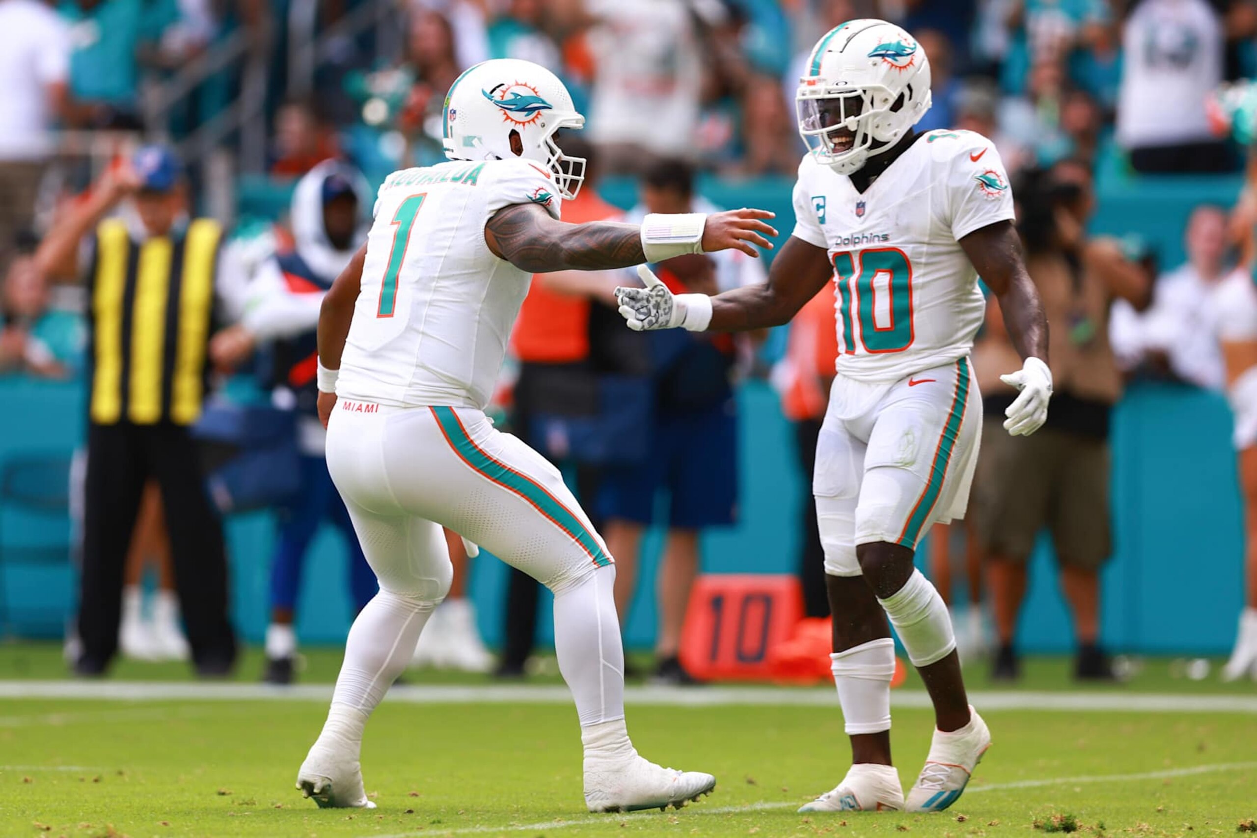 MIAMI GARDENS, FLORIDA - SEPTEMBER 24: Tua Tagovailoa #1 of the Miami Dolphins and Tyreek Hill #10 of the Miami Dolphins celebrate after a Miami touchdown during the third quarter against the Denver Broncos at Hard Rock Stadium on September 24, 2023 in Miami Gardens, Florida. (Photo by Megan Briggs/Getty Images)