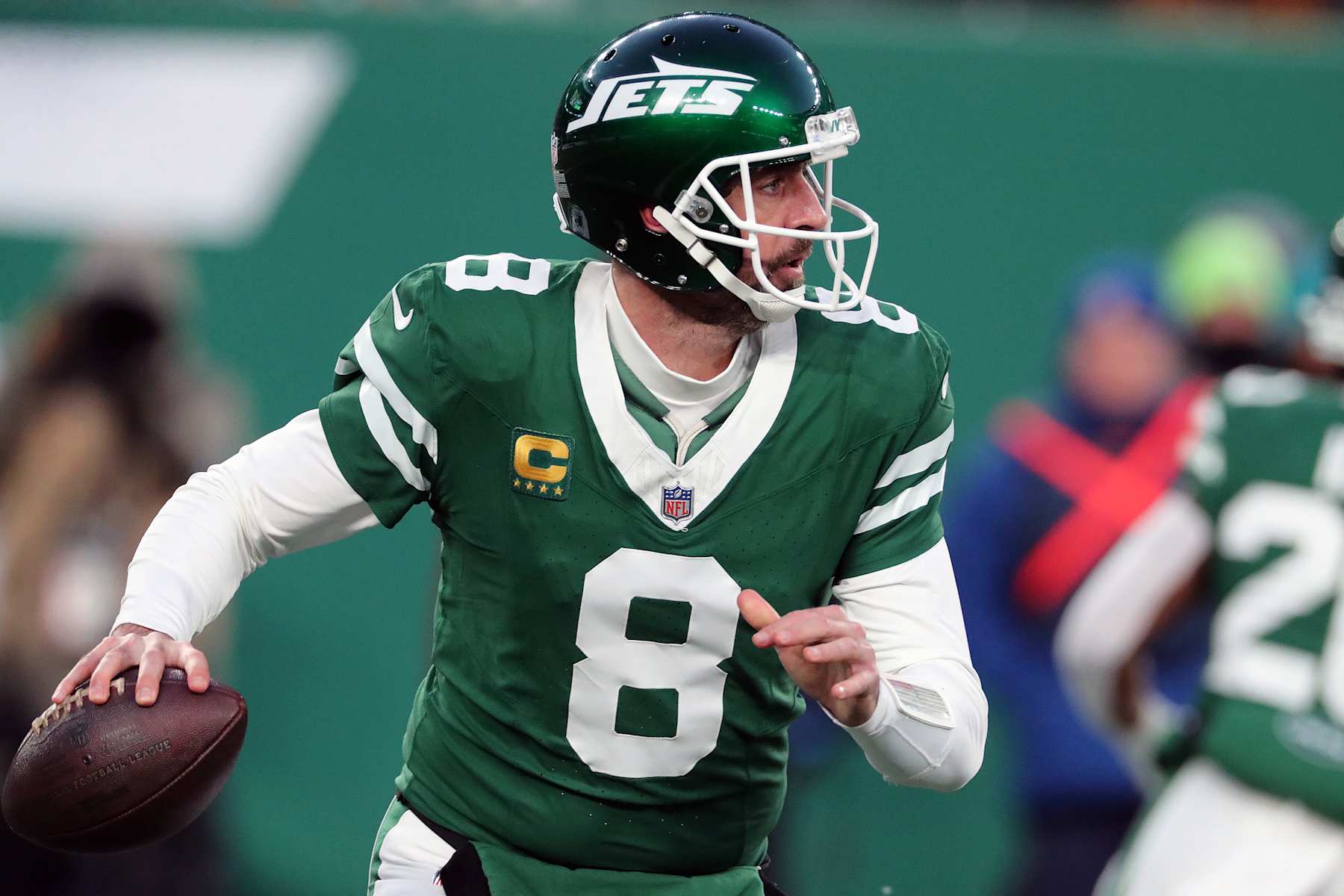 EAST RUTHERFORD, NEW JERSEY - JANUARY 5: Quarterback Aaron Rodgers #8 of the New York Jets rolls out to pass the ball in the game between the Miami Dolphins against the New York Jets at MetLife Stadium on January 5, 2025 in East Rutherford, New Jersey. (Photo by Al Pereira/Getty Images)