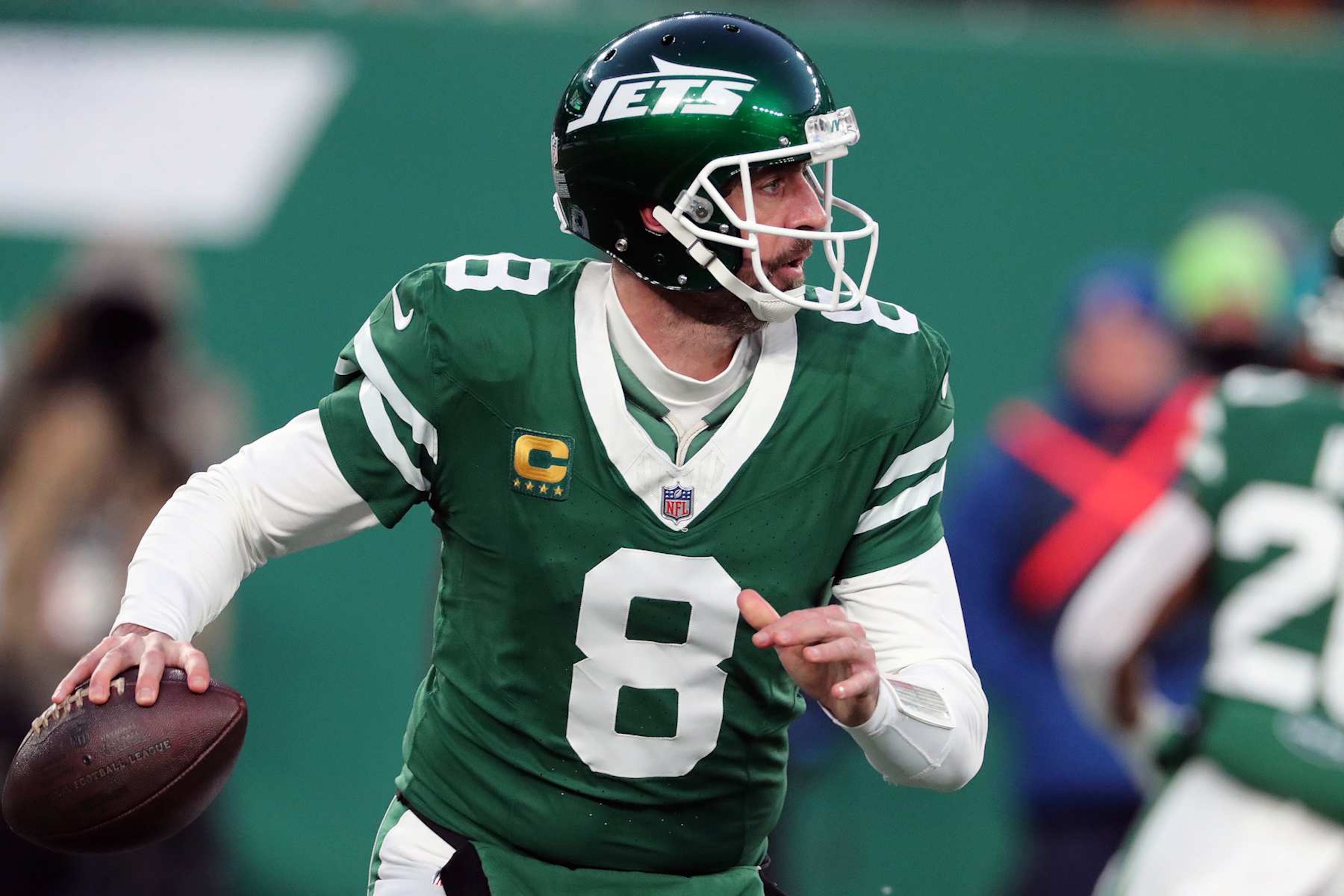 EAST RUTHERFORD, NEW JERSEY - JANUARY 5: Quarterback Aaron Rodgers #8 of the New York Jets rolls out to pass the ball in the game between the Miami Dolphins against the New York Jets at MetLife Stadium on January 5, 2025 in East Rutherford, New Jersey. (Photo by Al Pereira/Getty Images)