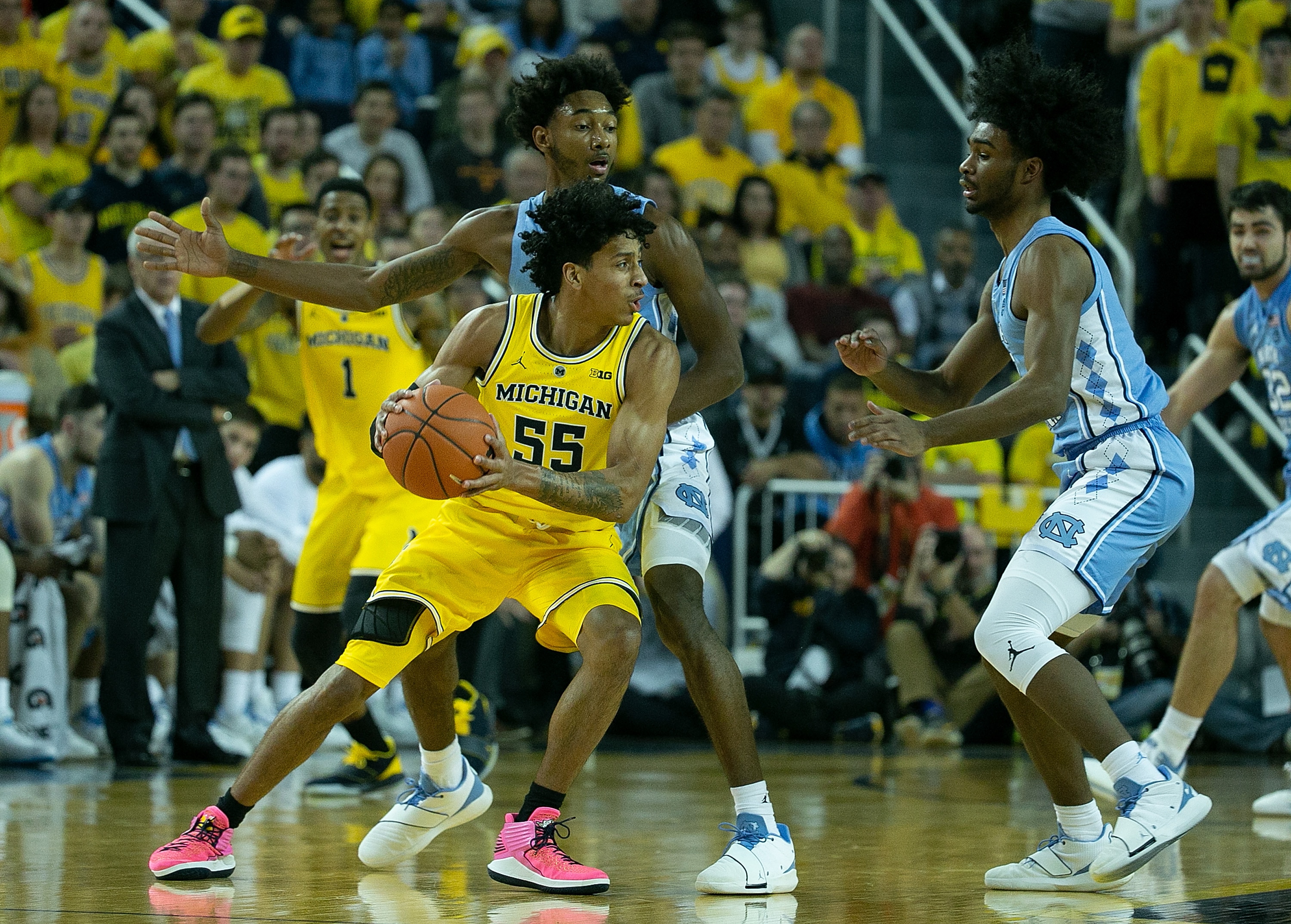 ANN ARBOR, MI - NOVEMBER 28: Eli Brooks #55 of the Michigan Wolverines looks to drive the ball as Kenny Williams #24 of the North Carolina Tar Heels defends during the first half of the game at Crisler Center on November 28, 2018 in Ann Arbor, Michigan. Michigan defeated North Carolina Tar Heels 84-67. (Photo by Leon Halip/Getty Images)