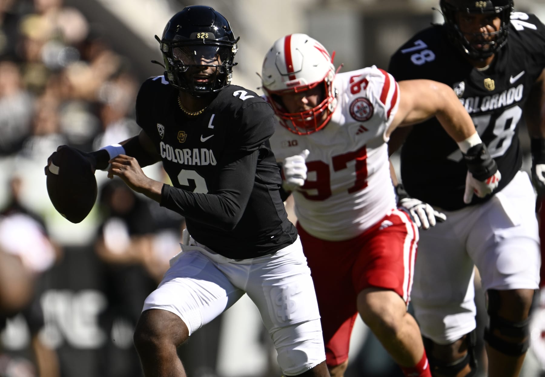 BOULDER, COLORADO - AUGUST 9: Colorado Buffaloes quarterback Shedeur Sanders (2) looks for somewhere to pass as he is be chased by Nebraska Cornhuskers defensive lineman Blaise Gunnerson (97) during the first half at Folsom Field on September 9, 2023 in Boulder, Colorado. Head Coach Deion Sanders led the Colorado Buffaloes in a matchup against their long-time rivals, the Nebraska Cornhuskers, during Coach Prime's highly anticipated home debut. (Photo by RJ Sangosti/MediaNews Group/The Denver Post via Getty Images)