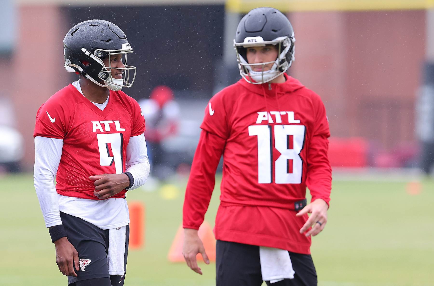 FLOWERY BRANCH, GEORGIA - MAY 14:  Quarterback Michael Penix Jr. #9 of the Atlanta Falcons looks on behind quarterback Kirk Cousins #18 during OTA offseason workouts at the Atlanta Falcons training facility on May 14, 2024 in Flowery Branch, Georgia. (Photo by Kevin C. Cox/Getty Images)