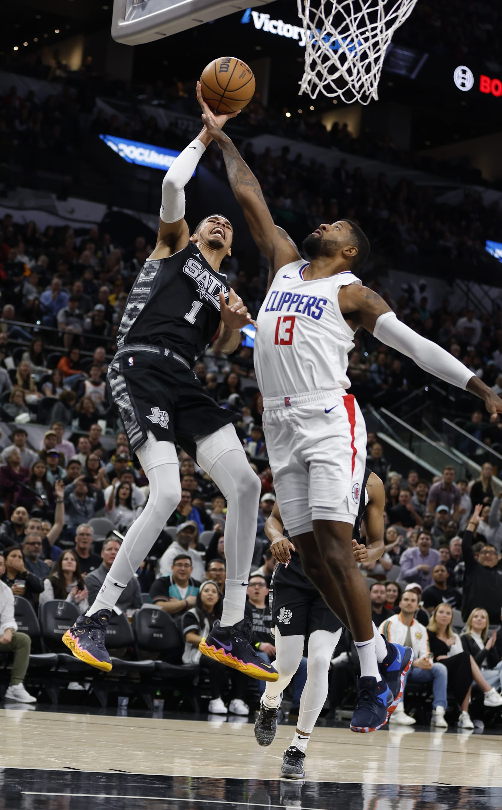 SAN ANTONIO, TX - NOVEMBER 22:   Victor Wembanyama #1 of the San Antonio Spurs is fouled by Paul George #13 of the Los Angeles Clippers in the first half at Frost Bank Center on November  22, 2023 in San Antonio, Texas. NOTE TO USER: User expressly acknowledges and agrees that, by downloading and or using this photograph, User is consenting to terms and conditions of the Getty Images License Agreement. (Photo by Ronald Cortes/Getty Images)