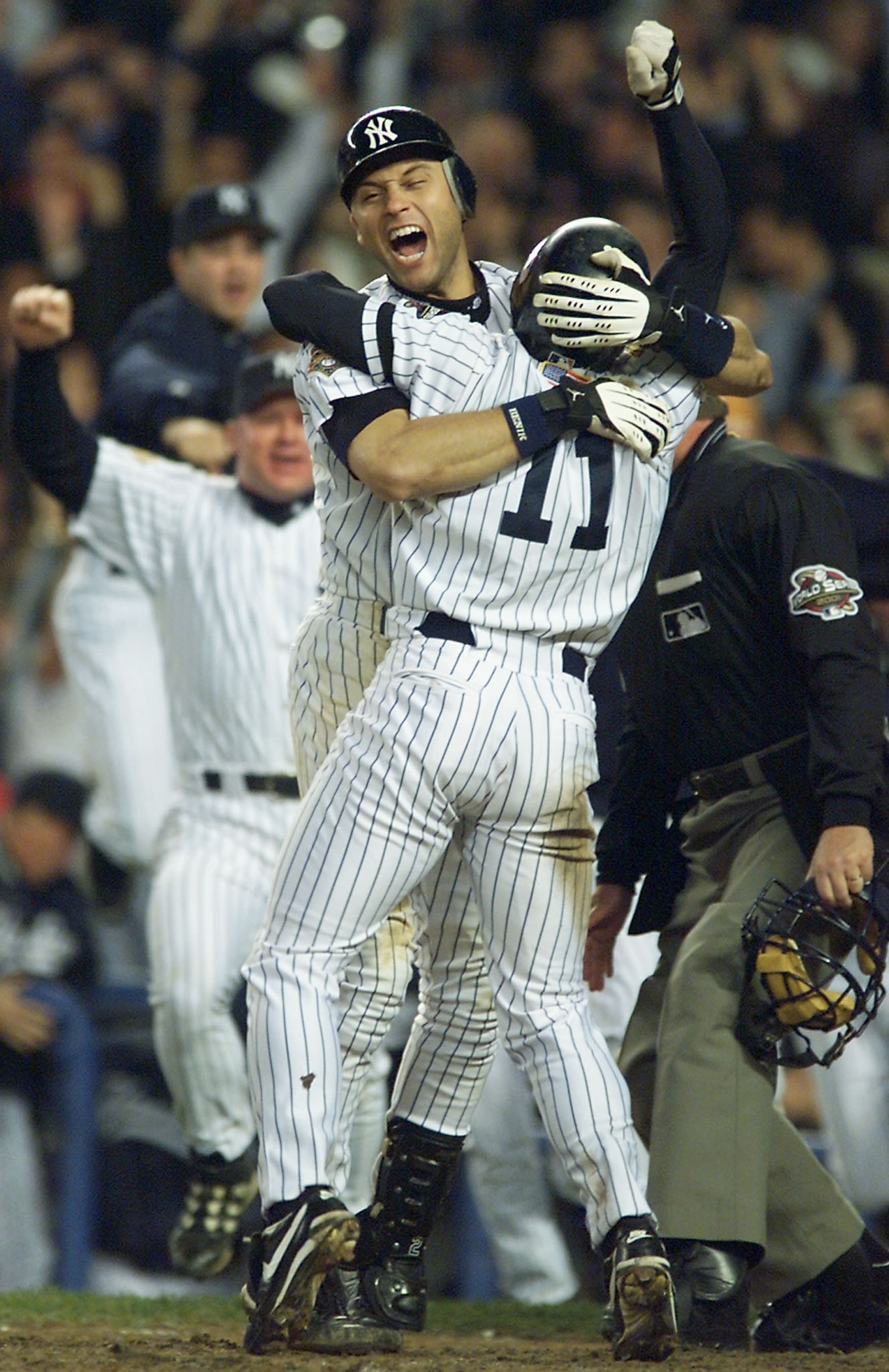 NEW YORK, UNITED STATES:  New York Yankees shortstop Derek Jeter (L) hugs teammate Chuck Knoblauch after Knoblauch scored the winning run in the bottom of the 12th inning of Game 5 of the World Series at the  Yankee Stadium in Ne York 01 November, 2001. The Yankees defeated the Arizona Diamondbacks 3-2 and took a lead of 3-2 in the series.  AFP PHOTO/Timothy A. CLARY (Photo credit should read TIMOTHY A. CLARY/AFP via Getty Images)