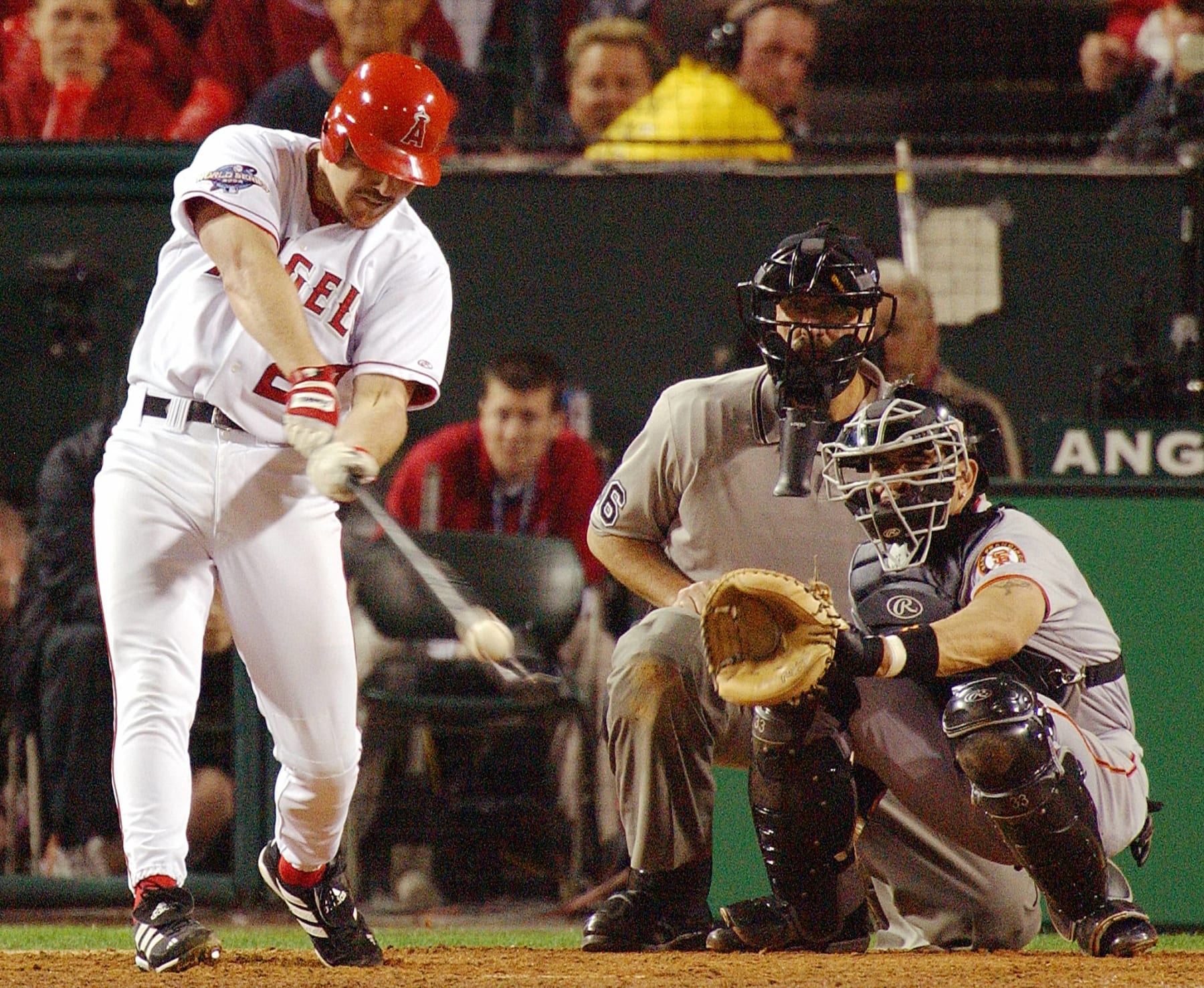 Anaheim Angels Scott Spiezio hits a three-run homerun as San Francisco Giants catcher Benito Santiago (R) and home plate umpire Tim McClelland (C) watch in the seventh inning of Game 6 of the World Series in Anaheim, CA, 26 October, 2002. The Giants are leading the best-of-seven series 3-2.  AFP PHOTO Lucy NICHOLSON (Photo by LUCY NICHOLSON / AFP) (Photo by LUCY NICHOLSON/AFP via Getty Images)