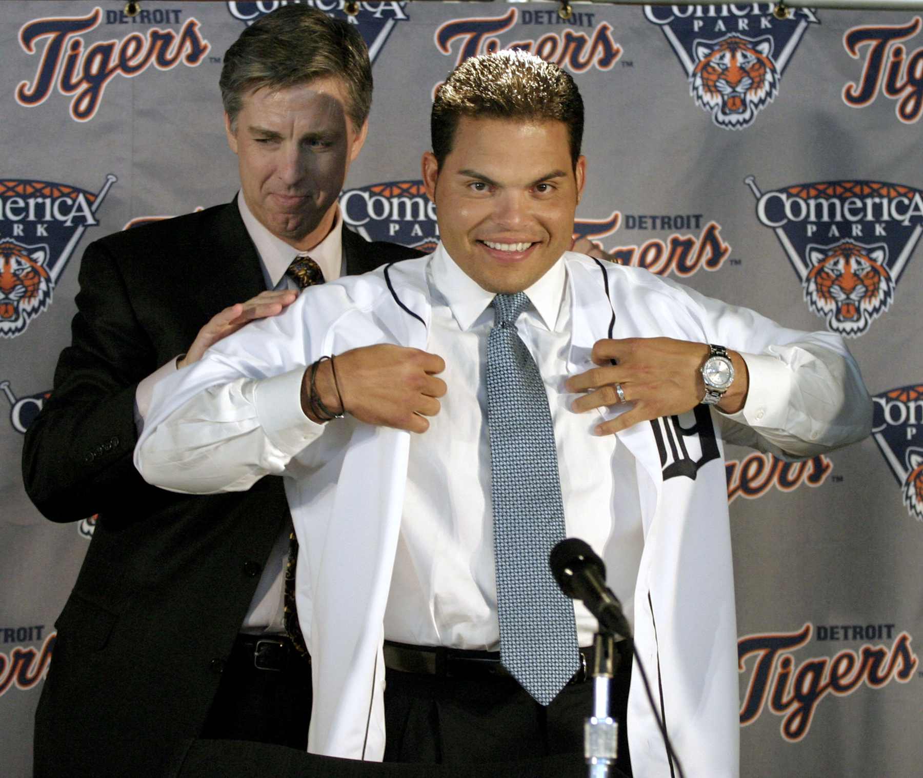 DETROIT, MI - FEBRUARY 2:  Detroit Tigers' General Manager and team President David Dombrowski (L) helps  Ivan "Pudge" Rodriguez put on his new Detroit Tigers uniform on February 1, 2004 at Comerica Park in Detroit, Michigan. Rodriguez signed a four year, approximately $40 million contract with the Tigers.  (Photo by Bill Pugliano/Getty Images)