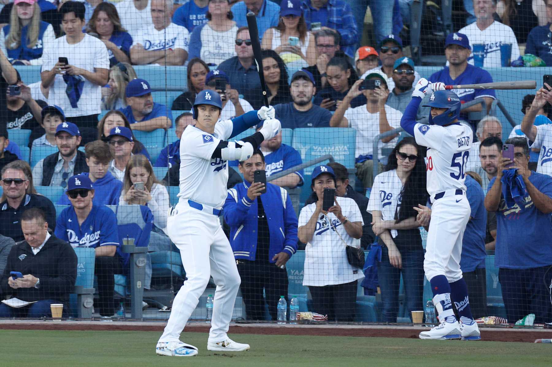 LOS ANGELES, CALIFORNIA - OCTOBER 13: Shohei Ohtani #17 and Mookie Betts #50 of the Los Angeles Dodgers prepare to bat in the first inning against the New York Mets during Game One of the Championship Series at Dodger Stadium on October 13, 2024 in Los Angeles, California. (Photo by Kevork Djansezian/Getty Images)
