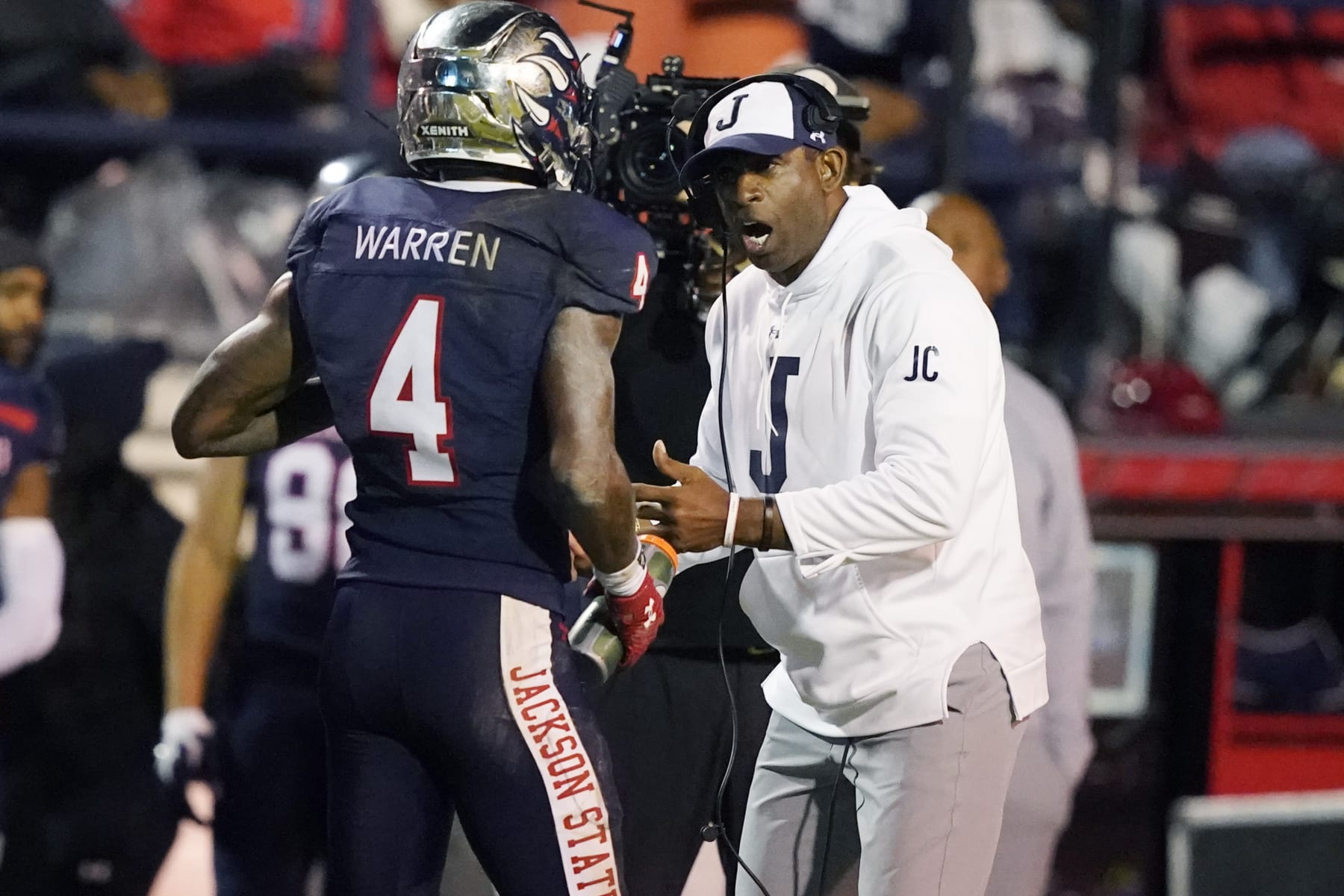 Jackson State head coach Deion Sanders, right, speaks with cornerback De'Jahn Warren (4) who comes off the field during the second half of the Southwestern Athletic Conference championship NCAA college football game against Southern, Saturday, Dec. 3, 2022, in Jackson, Miss. (AP Photo/Rogelio V. Solis)