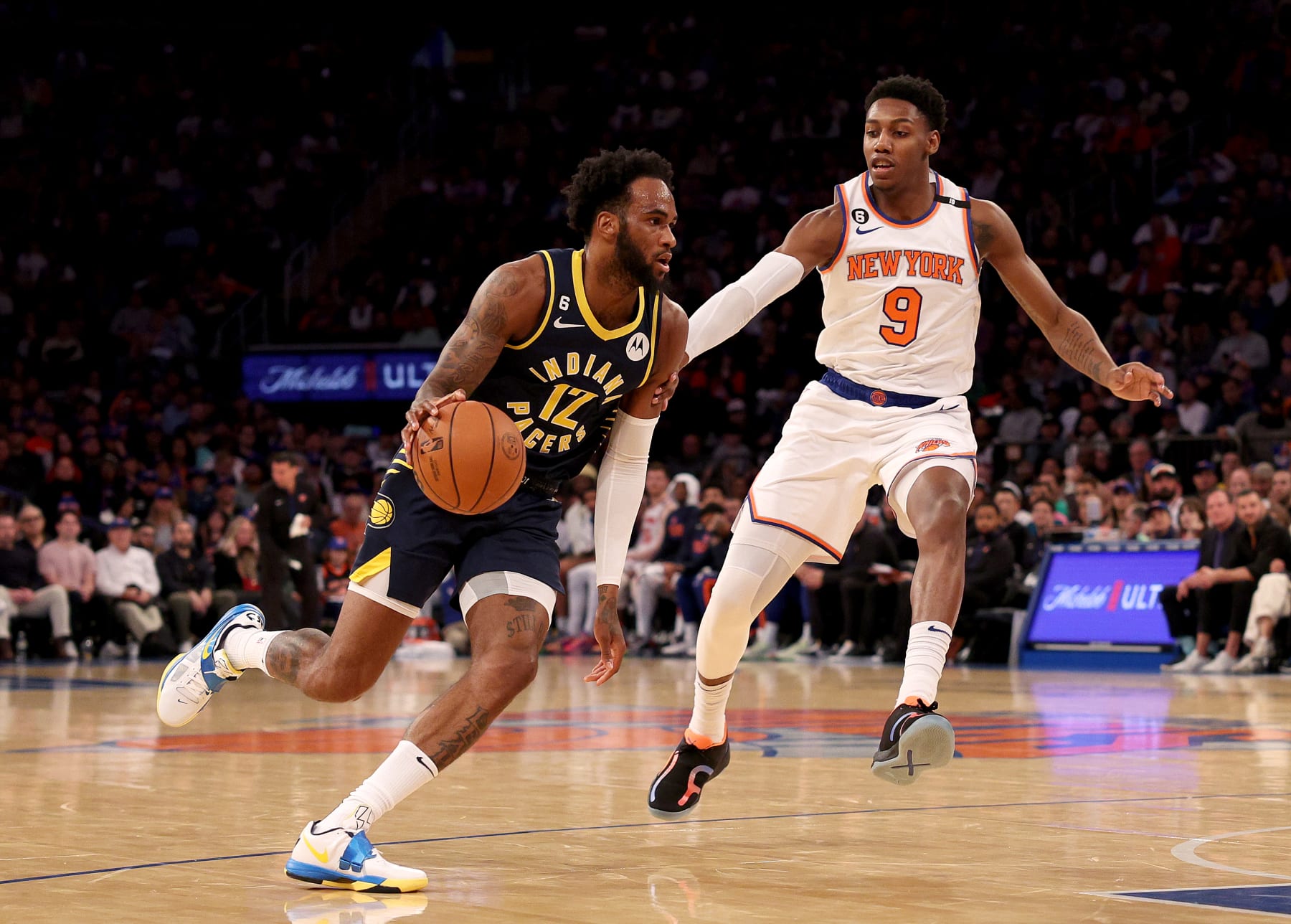 NEW YORK, NEW YORK - APRIL 09:  Oshae Brissett #12 of the Indiana Pacers drives to the net as RJ Barrett #9 of the New York Knicks defends at Madison Square Garden on April 09, 2023 in New York City. NOTE TO USER: User expressly acknowledges and agrees that, by downloading and or using this photograph, User is consenting to the terms and conditions of the Getty Images License Agreement. (Photo by Elsa/Getty Images)