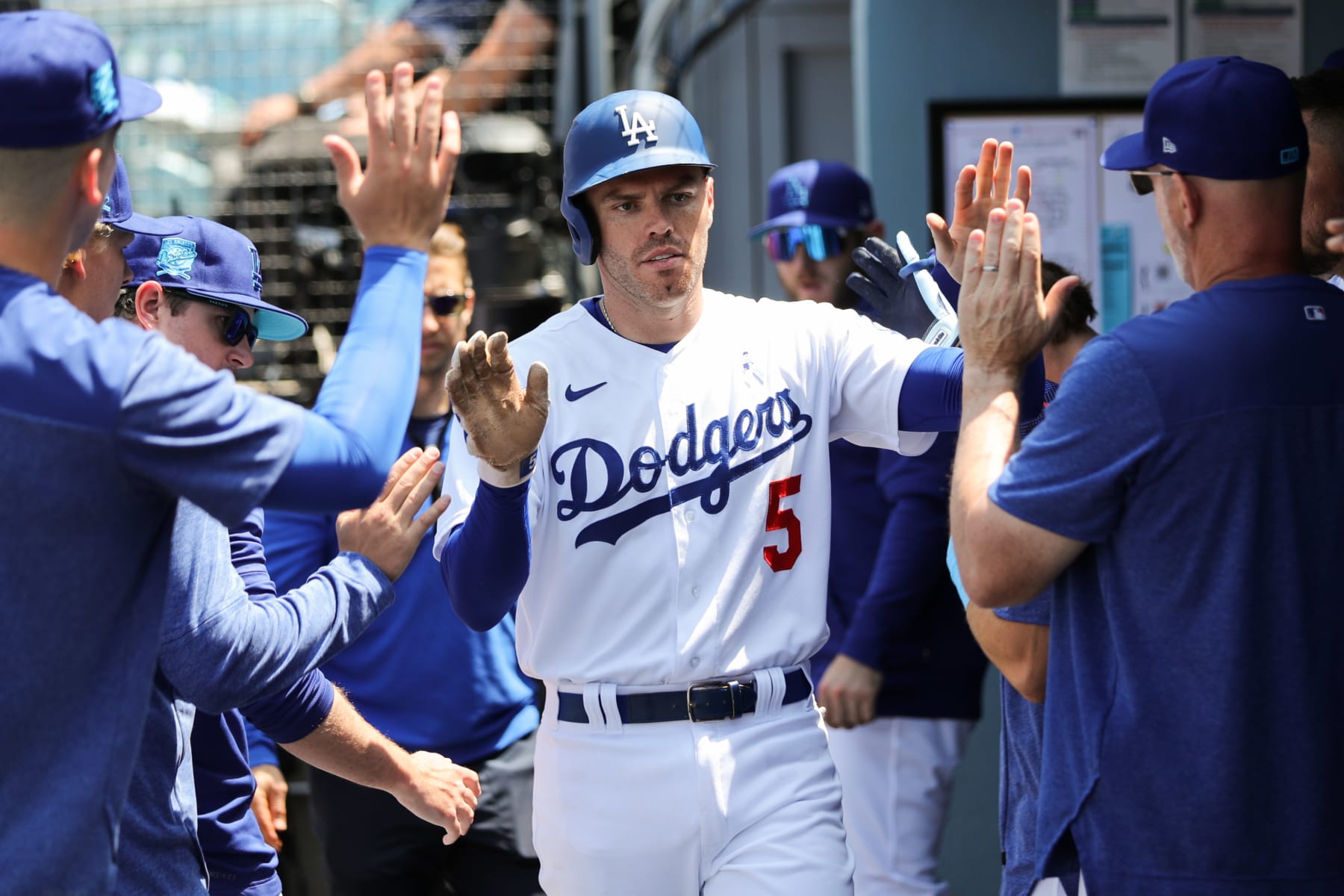 LOS ANGELES, CA - JUNE 18:   Freddie Freeman #5 of the Los Angeles Dodgers high-fives teammates in the dugout after scoring off a single from David Peralta #6 in the fifth inning during the game between the San Francisco Giants and the Los Angeles Dodgers at Dodger Stadium on Sunday, June 18, 2023 in Los Angeles, California. (Photo by Meg Oliphant/MLB Photos via Getty Images)
