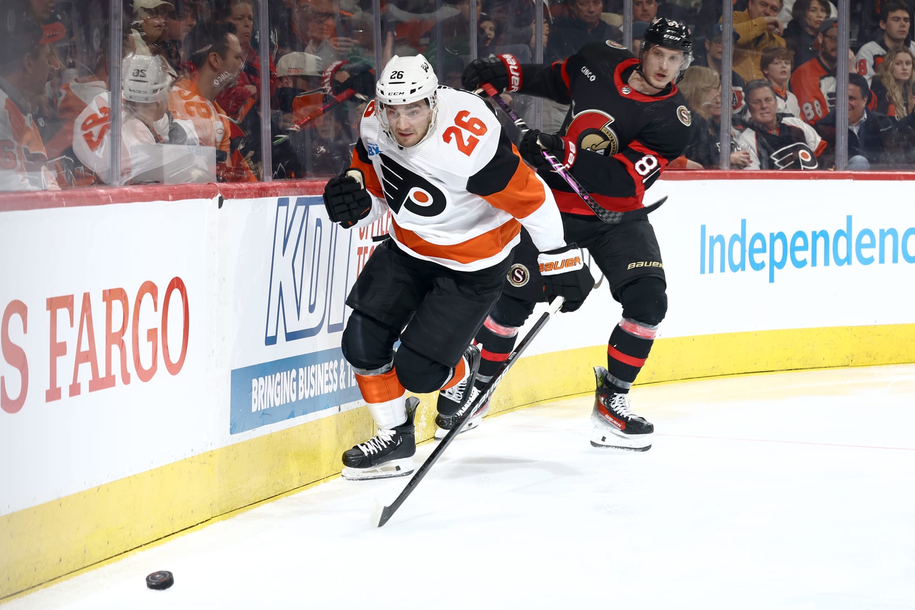 PHILADELPHIA, PENNSYLVANIA - MARCH 02: Sean Walker #26 of the Philadelphia Flyers chases the puck past Dominik Kubalik #81 of the Ottawa Senators during the third period at the Wells Fargo Center on March 02, 2024 in Philadelphia, Pennsylvania. (Photo by Tim Nwachukwu/Getty Images)