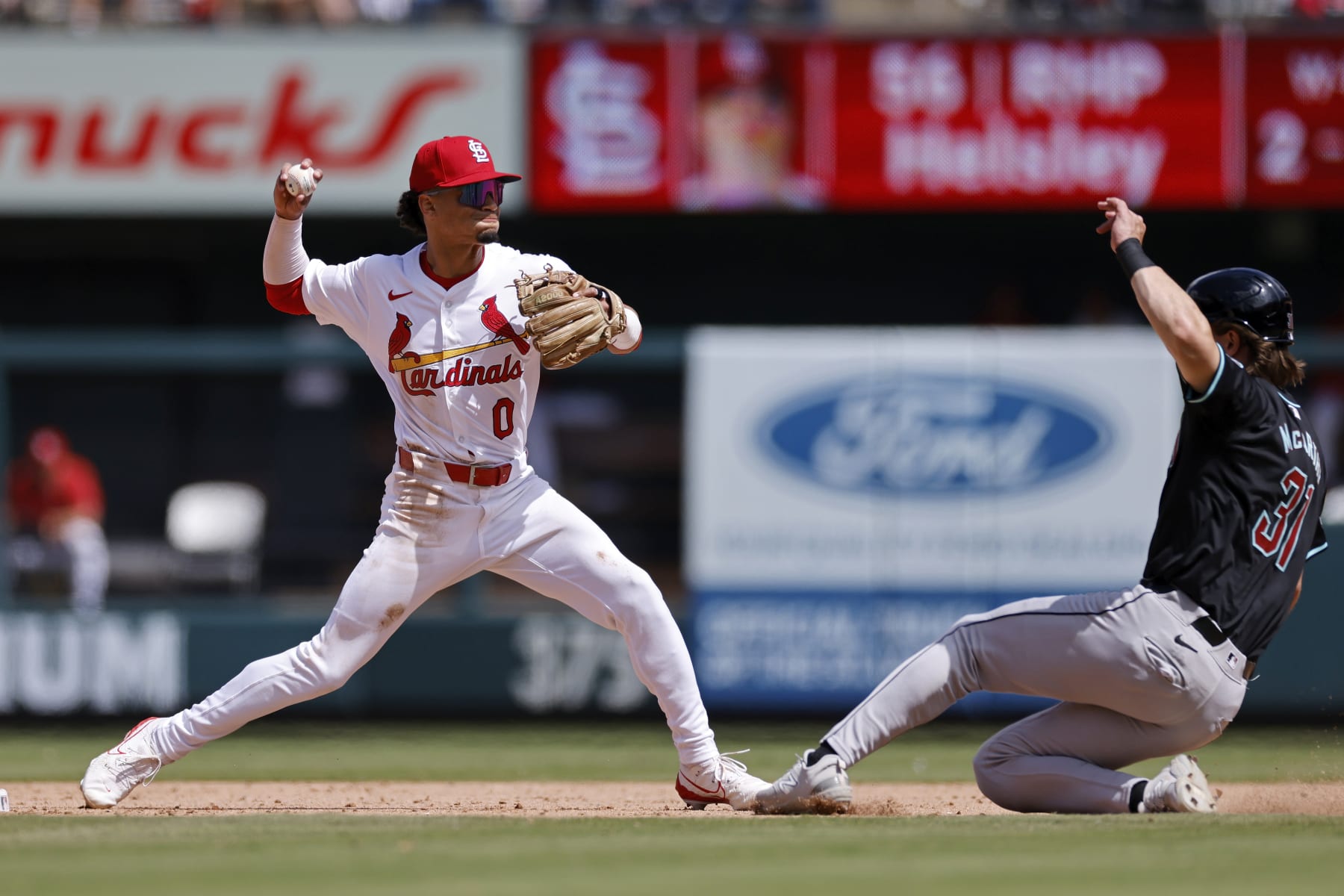 ST. LOUIS, MO - APRIL 24: St. Louis Cardinals shortstop Masyn Winn (0) turns a game-ending double play ahead of the slide by Arizona Diamondbacks outfielder Jake McCarthy (31) during an MLB game on April 24, 2024 at Busch Stadium in St. Louis, Missouri. (Photo by Joe Robbins/Icon Sportswire via Getty Images)