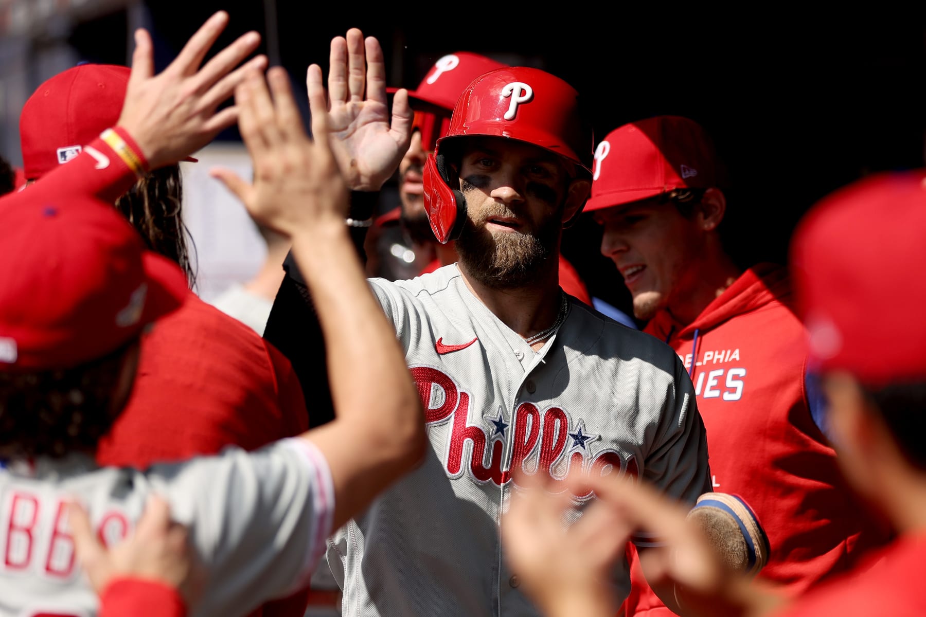 ATLANTA, GEORGIA - OCTOBER 11: Bryce Harper #3 of the Philadelphia Phillies celebrates in the dugout after scoring against the Atlanta Braves during the first inning in game one of the National League Division Series at Truist Park on October 11, 2022 in Atlanta, Georgia. (Photo by Patrick Smith/Getty Images)