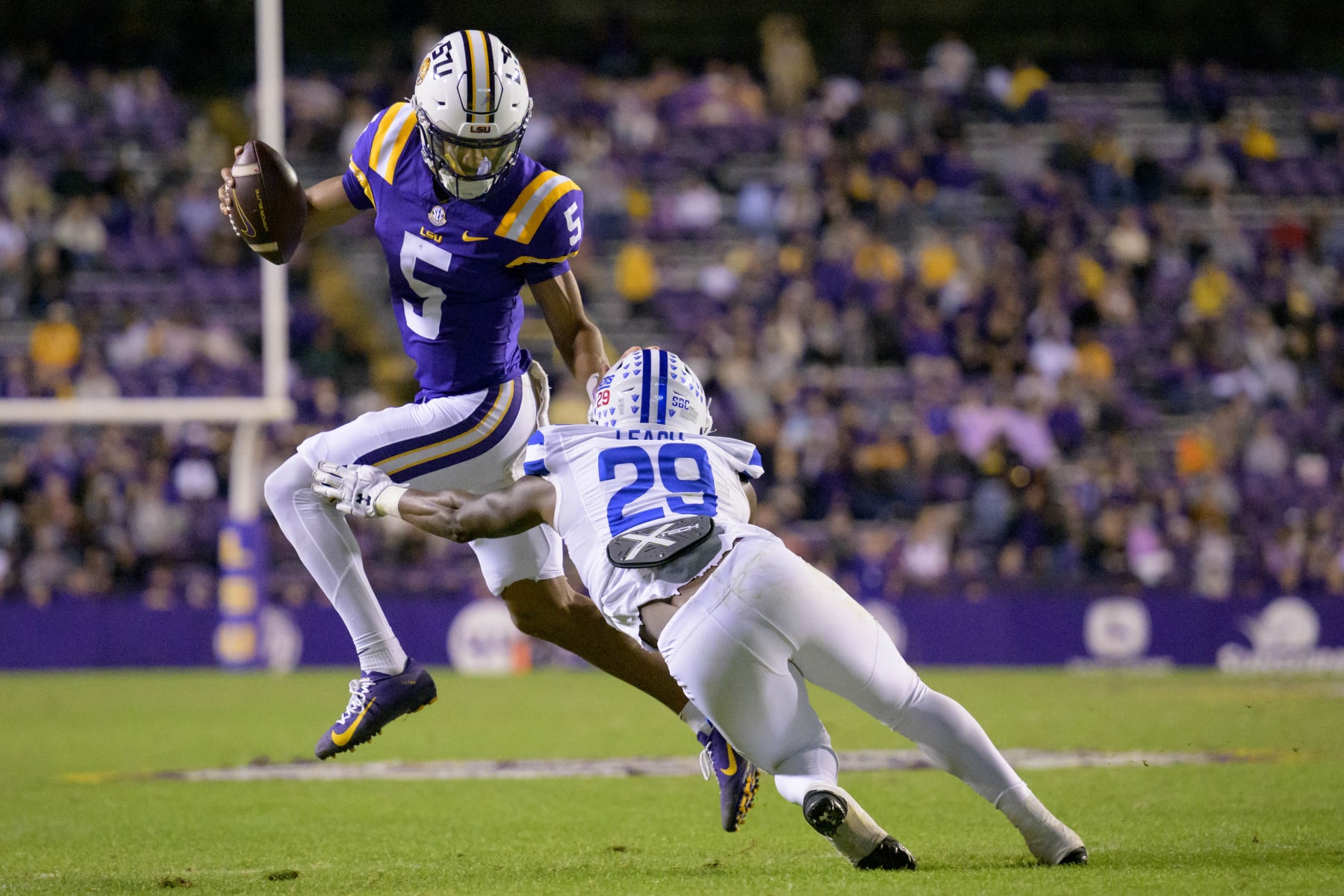 LSU quarterback Jayden Daniels (5) runs against Georgia State safety TyGee Leach (29) during the second half of an NCAA college football game in Baton Rouge, La., Saturday, Nov. 18, 2023. (AP Photo/Matthew Hinton)