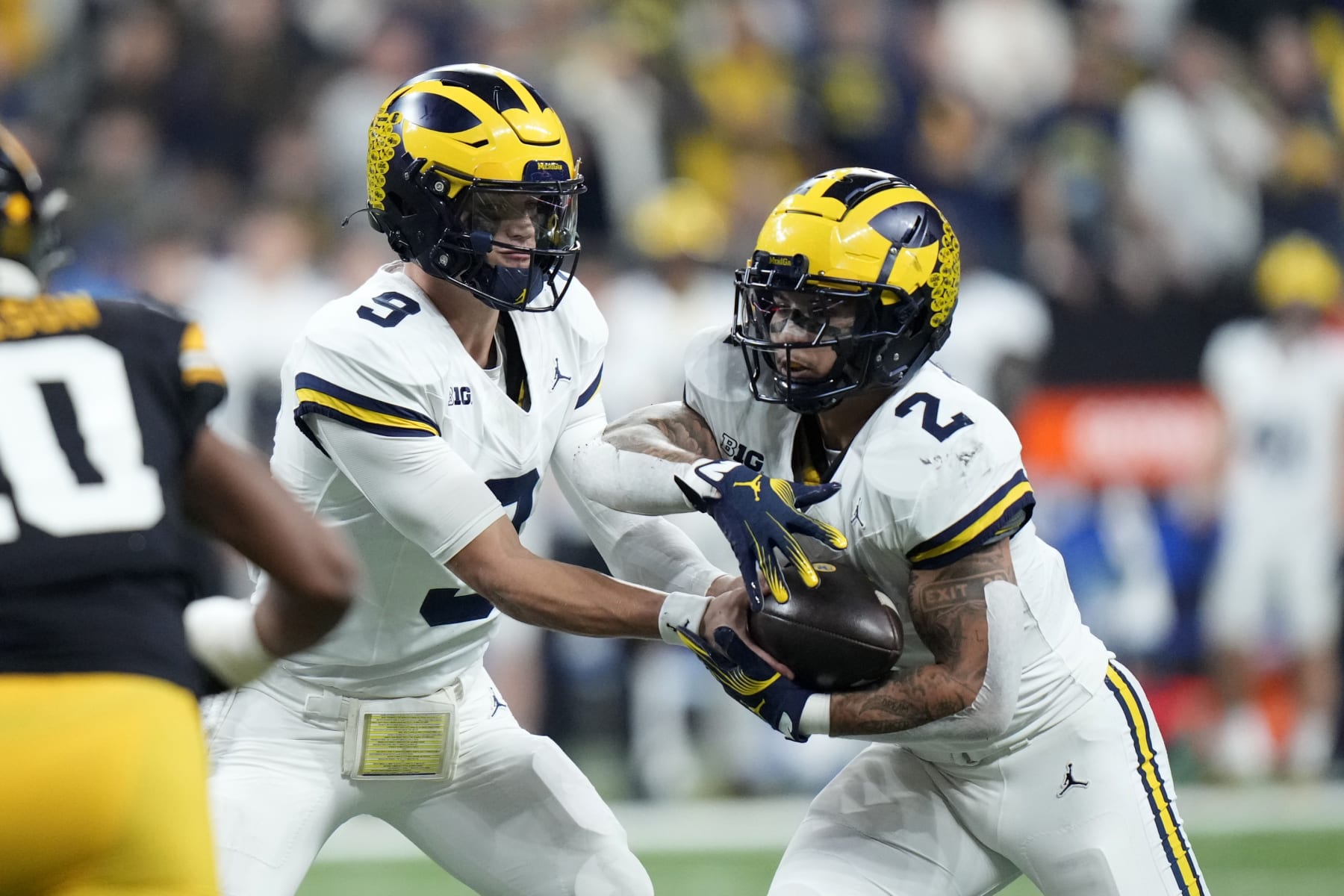 Michigan quarterback J.J. McCarthy (9) hands the ball off to running back Blake Corum (2) during the first half of the Big Ten championship NCAA college football game against Iowa, Saturday, Dec. 2, 2023, in Indianapolis. (AP Photo/AJ Mast)