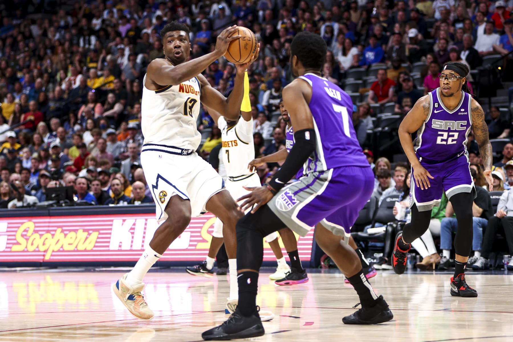 DENVER, CO - APRIL 09: Thomas Bryant #13 of the Denver Nuggets looks to pass the ball around Chimezie Metu #7 of the Sacramento Kings during the second half at Ball Arena on April 9, 2023 in Denver, Colorado. NOTE TO USER: User expressly acknowledges and agrees that, by downloading and or using this photograph, User is consenting to the terms and conditions of the Getty Images License Agreement. (Photo by Grace Bradley/Getty Images)