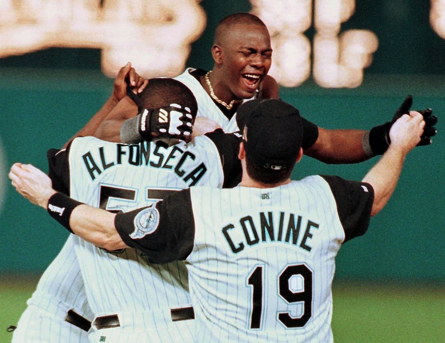 Florida Marlins player Edgar Renteria (C) celebrates his game-winning hit against the Cleveland Indians with teammates Antionio Alfoseca (L) and Jeff Conine 26 October after game seven of the World Series at Pro Player Stadium in Miami, FL. The Marlins beat the Indians 3-2 in 11 innings to win the World Series.  AFP PHOTO/Timothy A. CLARY (Photo by Timothy A. CLARY / AFP) (Photo by TIMOTHY A. CLARY/AFP via Getty Images)