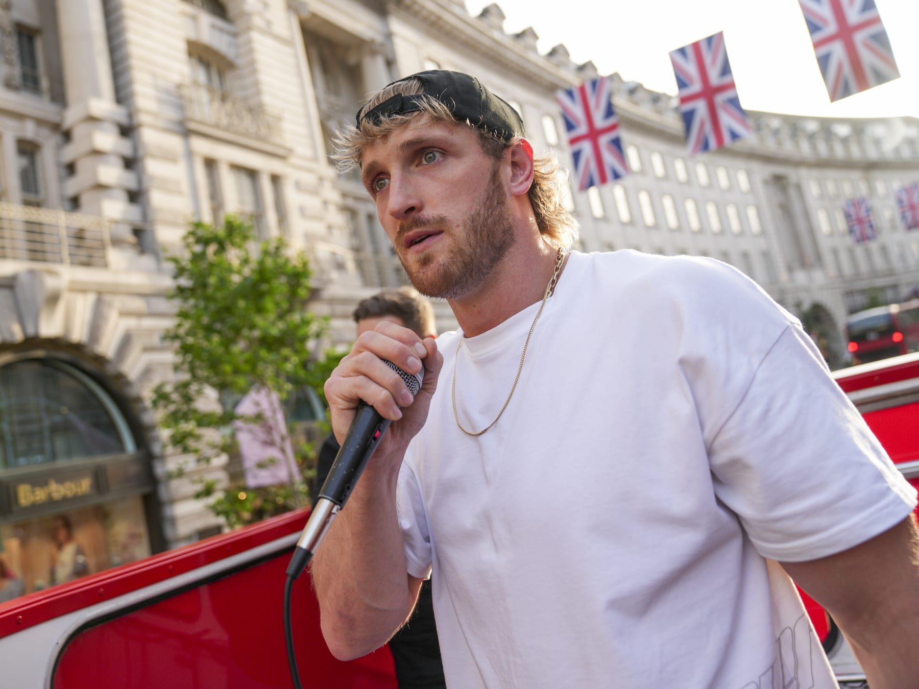 Logan Paul addresses the public whilst promoting an energy drink, on an open top bus traveling through London, Friday, June 17, 2022. (AP Photo/Scott Garfitt)