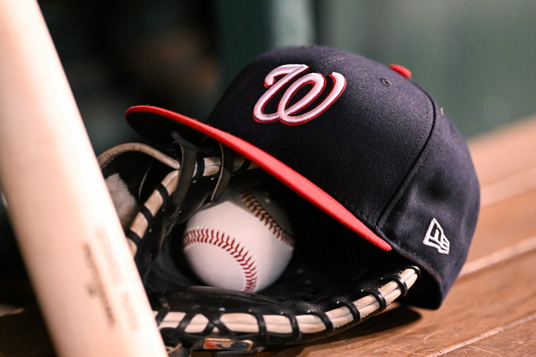 WASHINGTON, DC - AUGUST 12, 2022: A closeup view of a Washington Nationals hat on top of glove and baseball during the seventh inning against the San Diego Padres at Nationals Park on August 12, 2022 in Washington, DC. (Photo by Chris Bernacchi/Diamond Images via Getty Images)