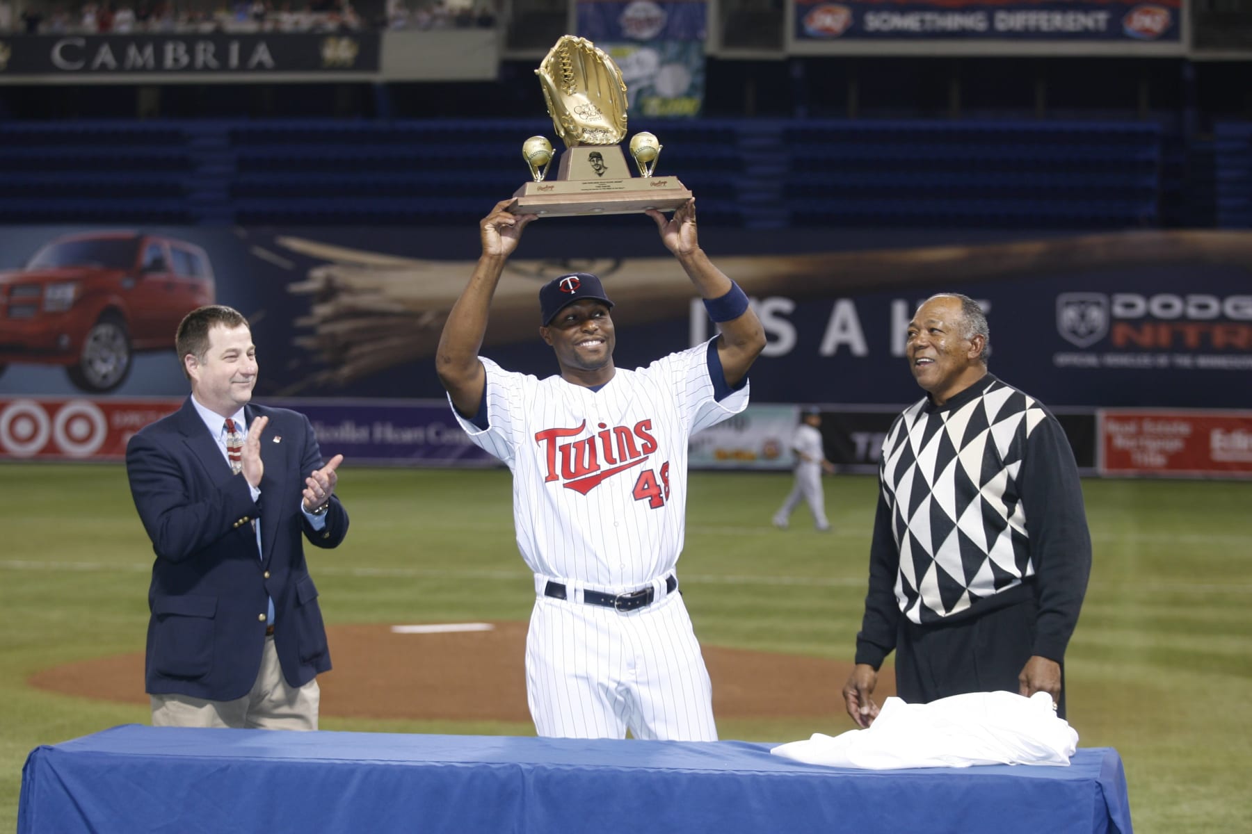 MINNEAPOLIS - APRIL 12:  Torii Hunter of the Minnesota Twins hoists his 2006 Golden Glove award with Rawlings representative Dan Phelps (left) and Tony Oliva in a pre-game ceremony prior to the game against the Tampa Bay Devil Rays at the Humphrey Metrodome in Minneapolis, Minnesota on April 12, 2007.  The  Twins defeated the Devil Rays 3-2.  (Photo by Bruce Kluckhohn/MLB Photos via Getty Images) 