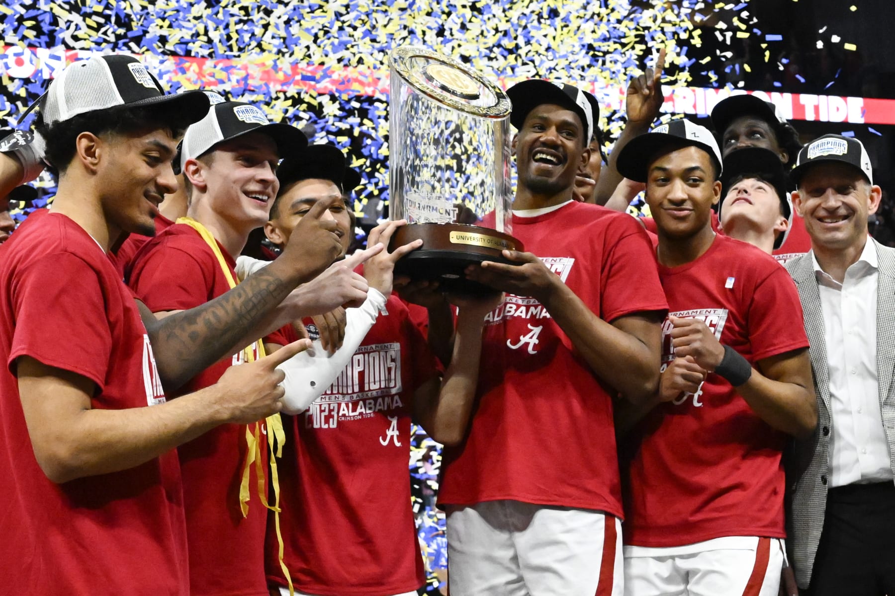 Alabama players pose with the trophy after an NCAA college basketball game against Texas A&M in the finals of the Southeastern Conference Tournament, Sunday, March 12, 2023, in Nashville, Tenn. Alabama won 82-63. (AP Photo/John Amis)