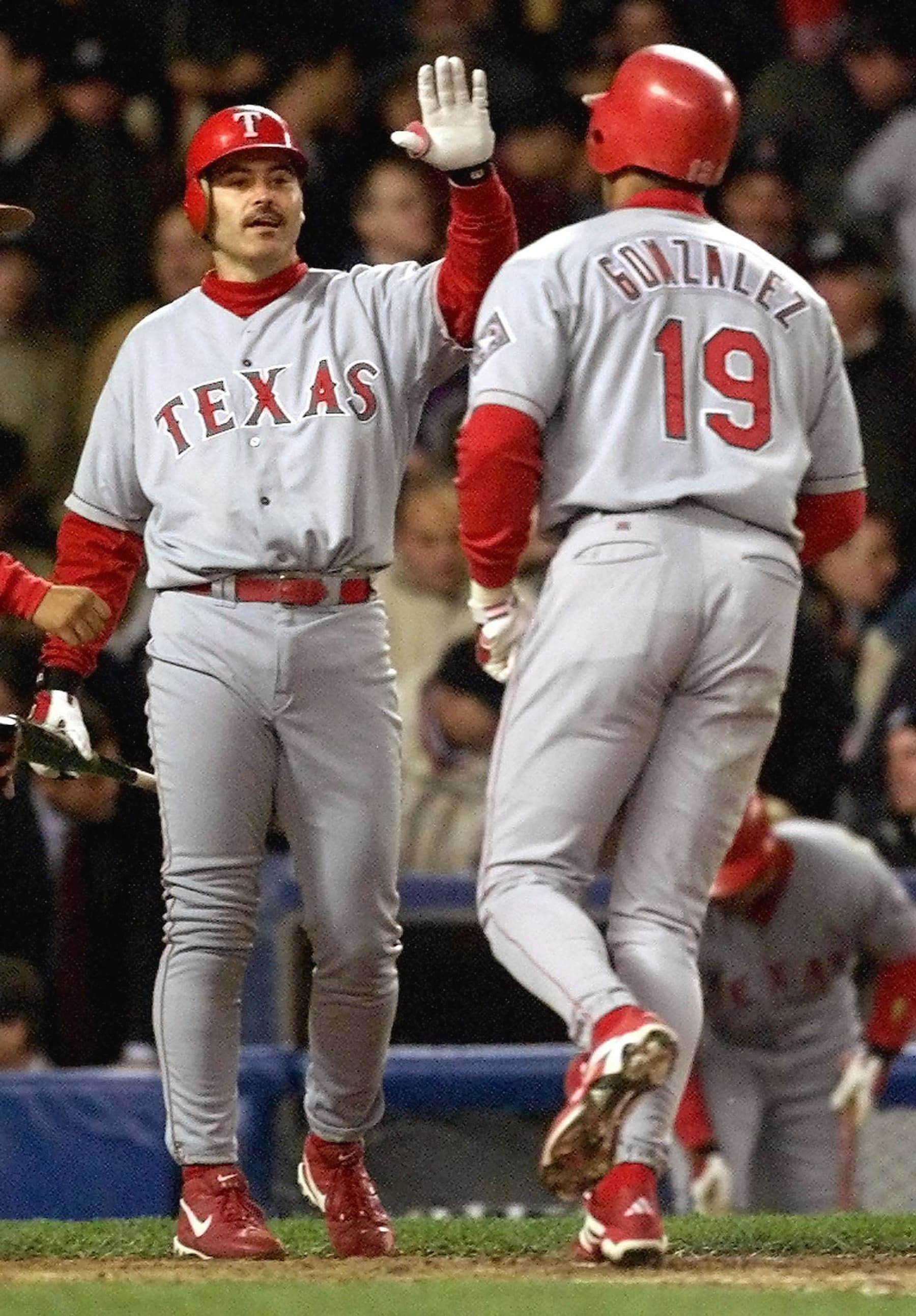 NEW YORK, UNITED STATES:  Texas Rangers designated hitter Rafael Palmeiro (L) congratulates teammate Juan Gonzalez (R) after he hit a solo home run in the top of the fourth inning of game two of the American League Division Series 07 October, 1999, at Yankee Stadium in New York. New York leads the best of five series 1-0. (ELECTRONIC IMAGE) AFP PHOTO/Timothy A. CLARY (Photo credit should read TIMOTHY A. CLARY/AFP via Getty Images)
