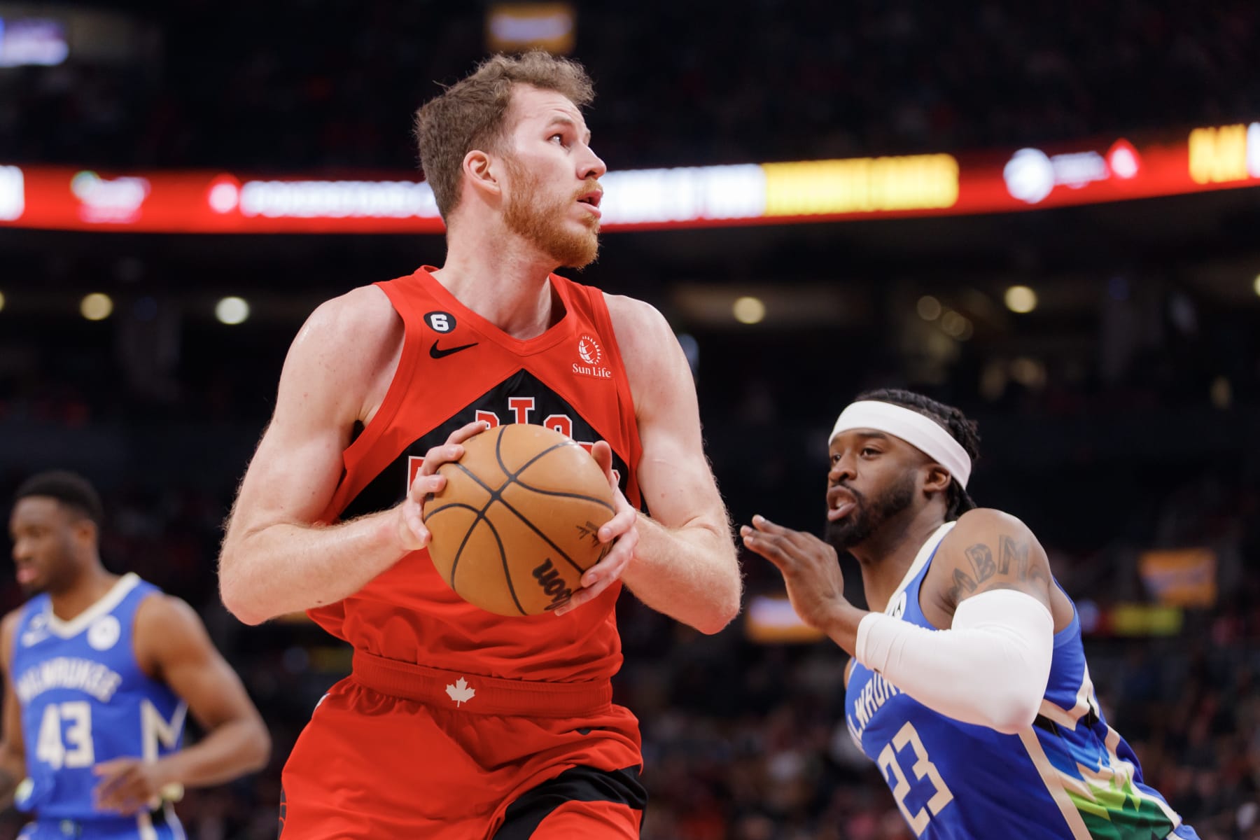 TORONTO, ON - APRIL 09: Jakob Poeltl #19 of the Toronto Raptors dribbles against Wesley Matthews #23 of the Milwaukee Bucks during the first half of their NBA game at Scotiabank Arena on April 9, 2023 in Toronto, Canada. NOTE TO USER: User expressly acknowledges and agrees that, by downloading and or using this photograph, User is consenting to the terms and conditions of the Getty Images License Agreement. (Photo by Cole Burston/Getty Images)