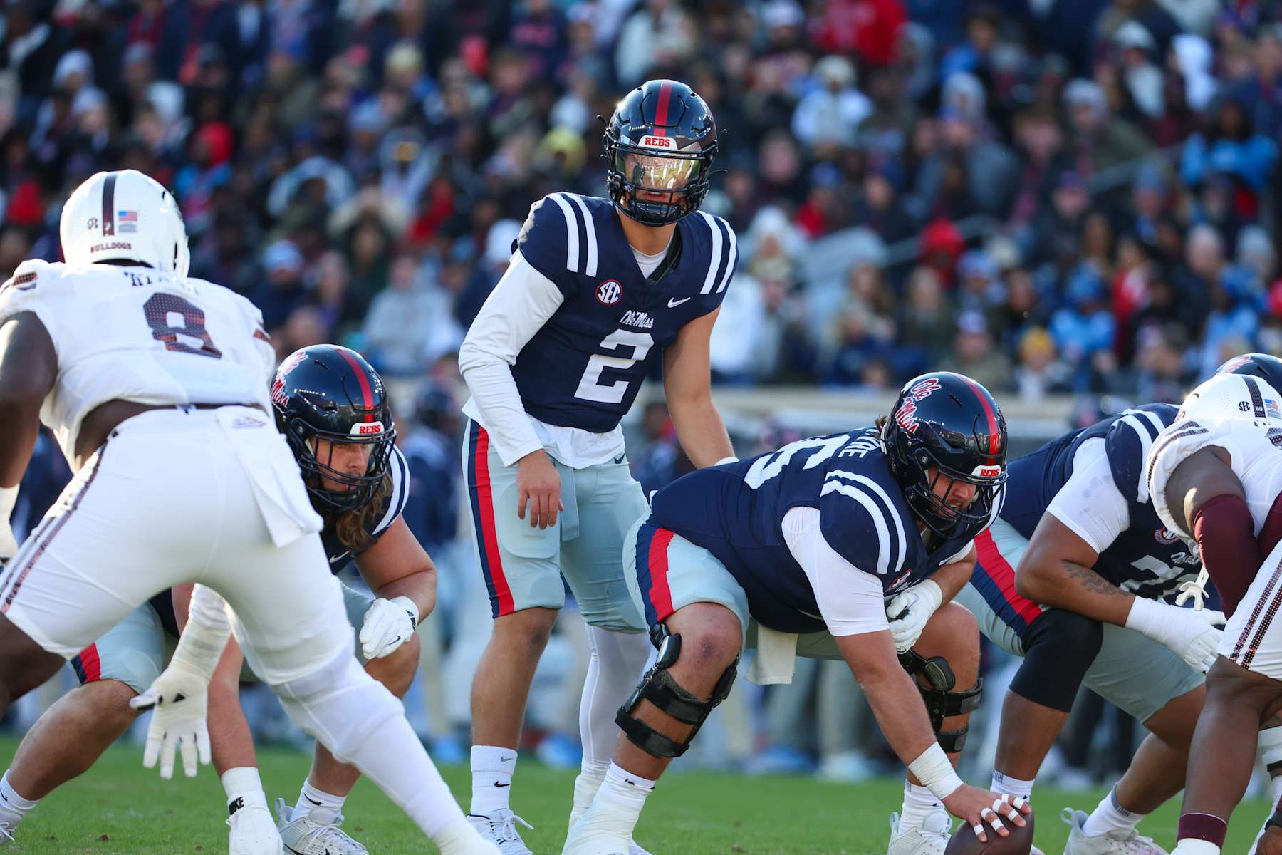 OXFORD, MISSISSIPPI - NOVEMBER 29: Jaxson Dart #2 and Reece McIntyre #56 of the Mississippi Rebels get set for a play against the Mississippi State Bulldogs during the first half at Vaught-Hemingway Stadium on November 29, 2024 in Oxford, Mississippi. (Photo by Wes Hale/Getty Images)