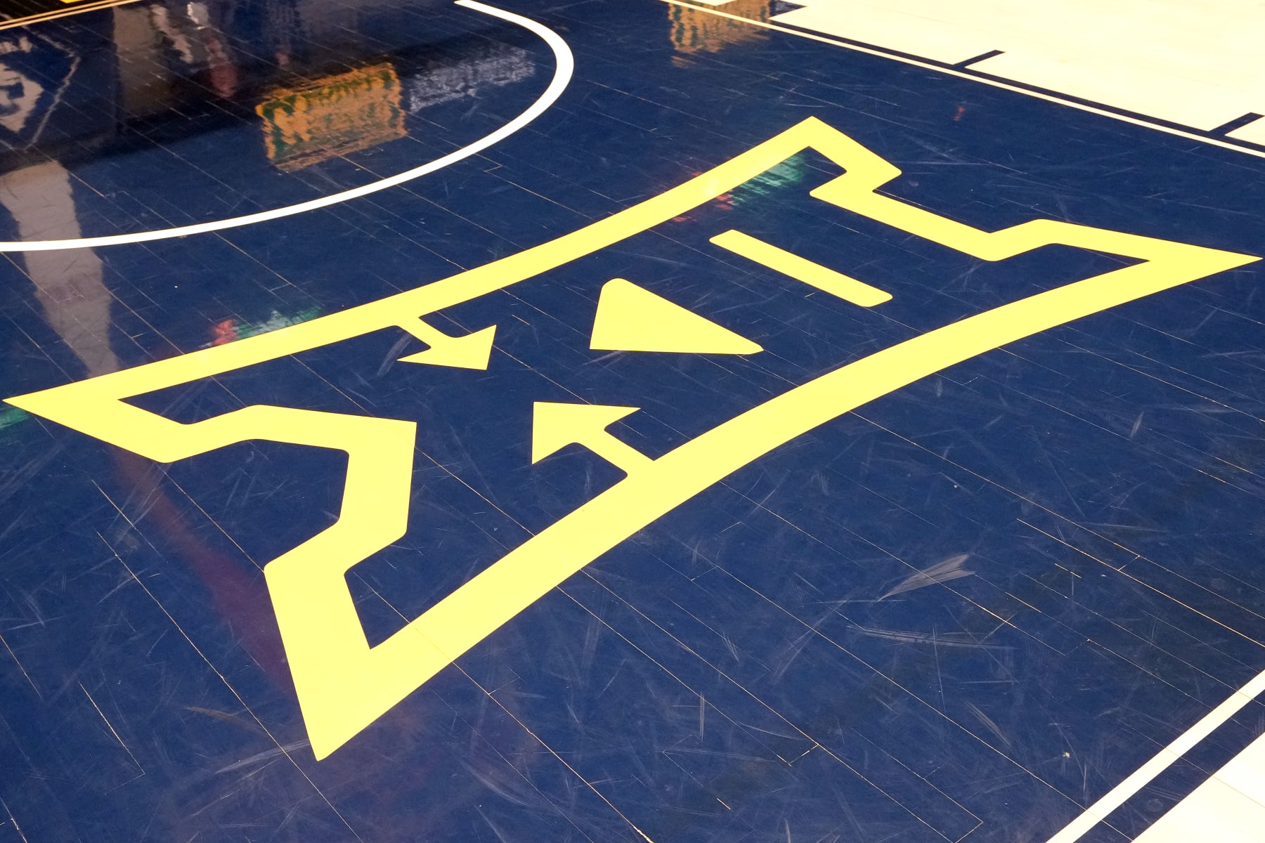 MORGANTOWN, WEST VIRGINIA - FEBRUARY 20:  Big XII logo on the floor before a college basketball game between Oklahoma State Cowboys and the the West Virginia Mountaineers at the WVU Coliseum on February 20, 2023 in Morgantown, West Virginia.  (Photo by Mitchell Layton/Getty Images)