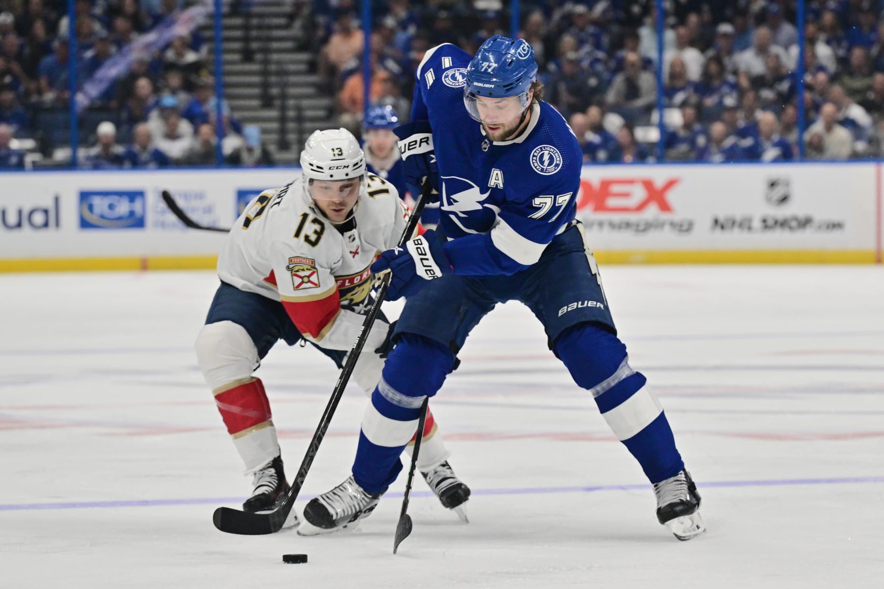 TAMPA, FLORIDA - APRIL 25: Victor Hedman #77 of the Tampa Bay Lightning handles the puck against Sam Reinhart #13 of the Florida Panthers in the first period during Game Three of the First Round of the 2024 Stanley Cup Playoffs at Amalie Arena on April 25, 2024 in Tampa, Florida.  (Photo by Julio Aguilar/Getty Images)