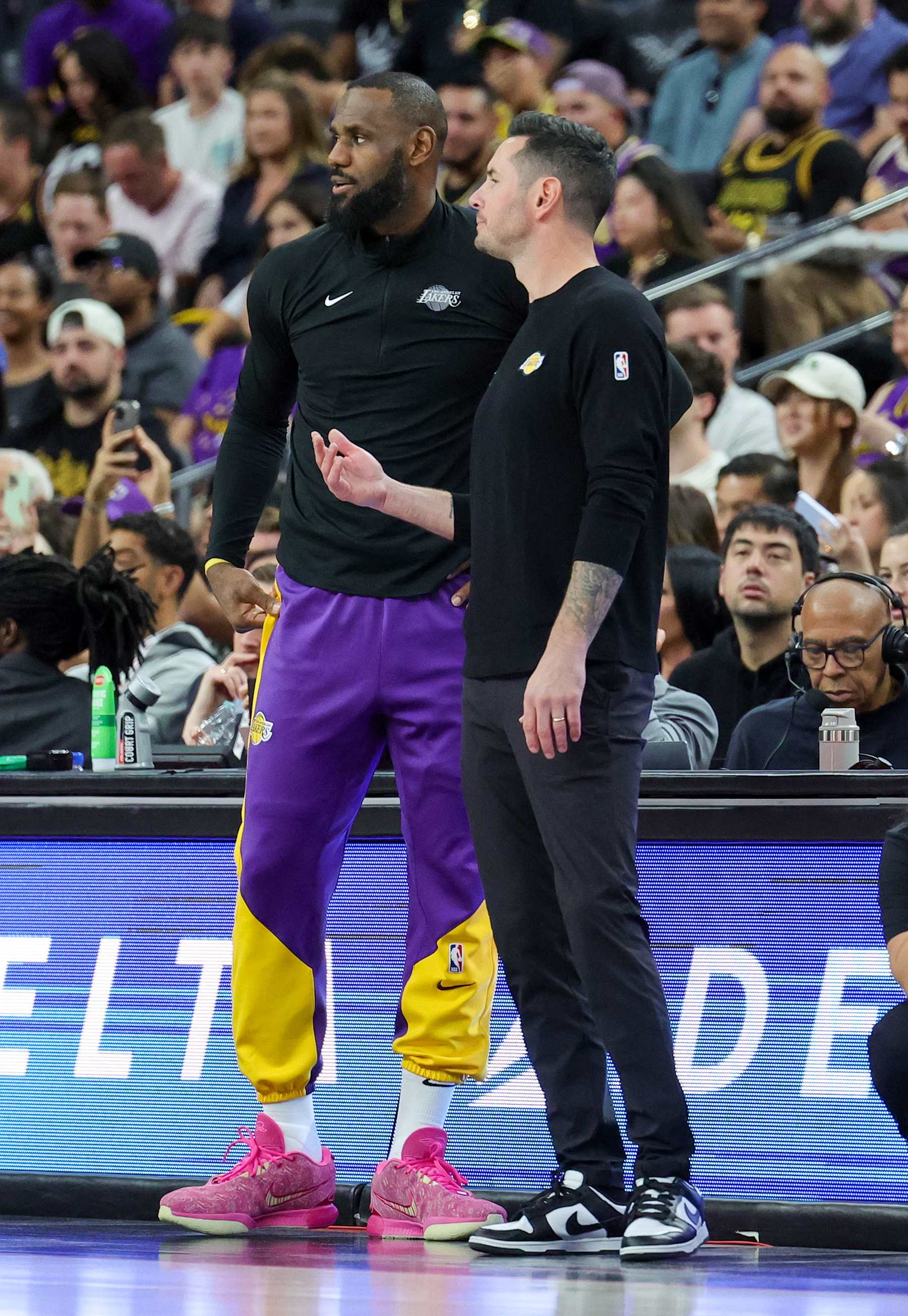 LAS VEGAS, NEVADA - OCTOBER 15: LeBron James (L) #23 and head coach JJ Redick of the Los Angeles Lakers talk in the first quarter of their preseason game against the Golden State Warriors at T-Mobile Arena at T-Mobile Arena on October 15, 2024 in Las Vegas, Nevada. The Warriors defeated the Lakers 111-97. NOTE TO USER: User expressly acknowledges and agrees that, by downloading and or using this photograph, User is consenting to the terms and conditions of the Getty Images License Agreement. (Photo by Ethan Miller/Getty Images)
