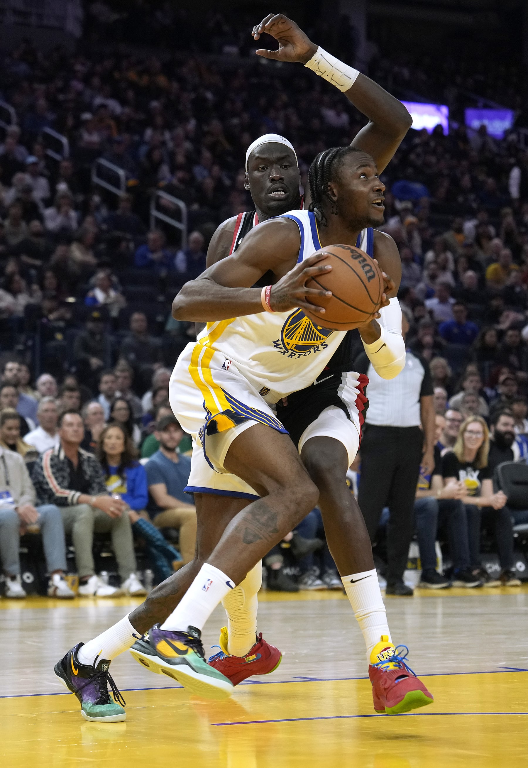 SAN FRANCISCO, CALIFORNIA - DECEMBER 06: Jonathan Kuminga #00 of the Golden State Warriors drives on Duop Reath #26 of the Portland Trail Blazers during the third quarter of an NBA basketball game at Chase Center on December 06, 2023 in San Francisco, California. NOTE TO USER: User expressly acknowledges and agrees that, by downloading and or using this photograph, User is consenting to the terms and conditions of the Getty Images License Agreement. (Photo by Thearon W. Henderson/Getty Images)