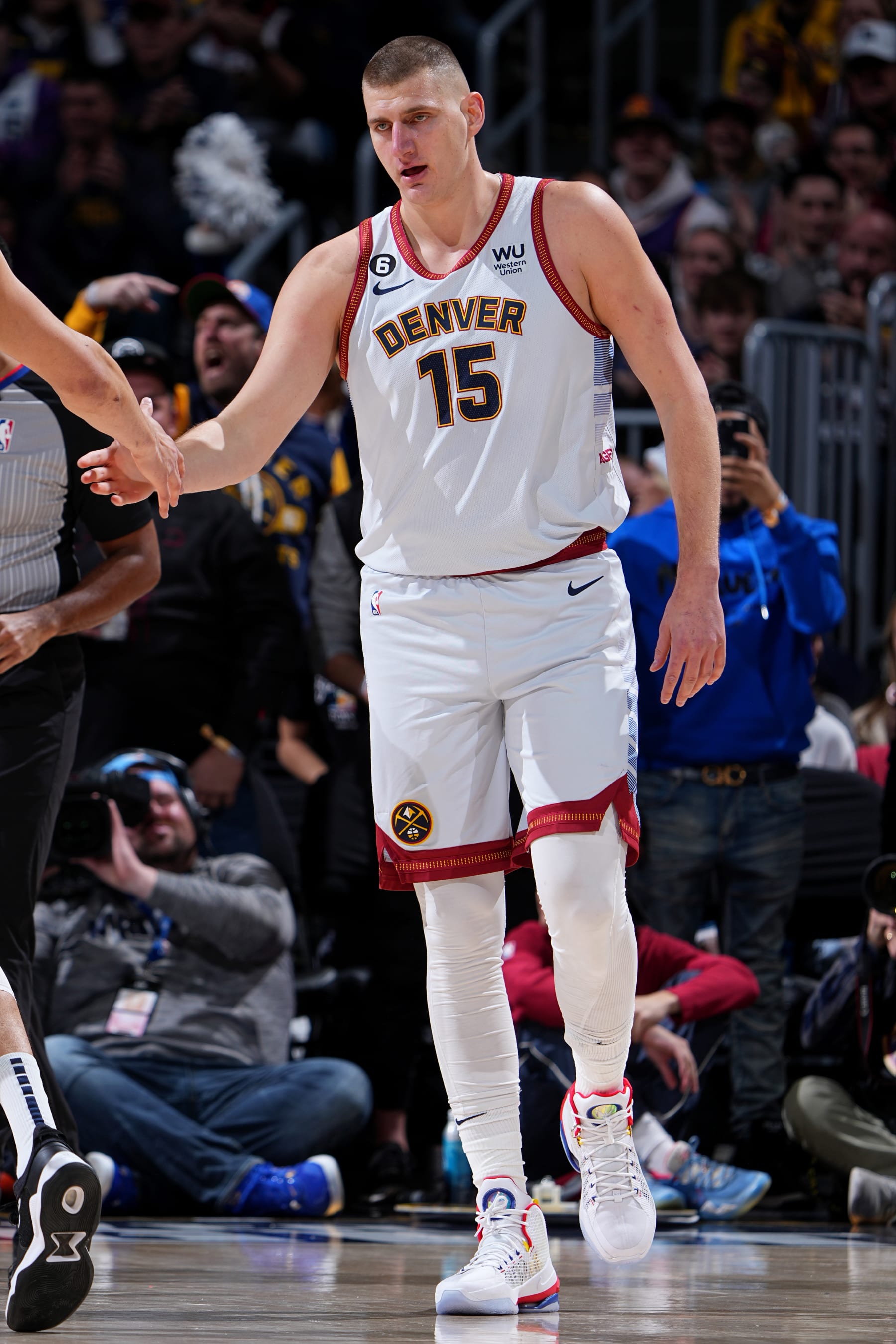 DENVER, CO - DECEMBER 25: Nikola Jokic #15 of the Denver Nuggets high fives a teammate during the game against the Phoenix Suns on December 25, 2022 at the Ball Arena in Denver, Colorado. NOTE TO USER: User expressly acknowledges and agrees that, by downloading and/or using this Photograph, user is consenting to the terms and conditions of the Getty Images License Agreement. Mandatory Copyright Notice: Copyright 2022 NBAE (Photo by Garrett Ellwood/NBAE via Getty Images)