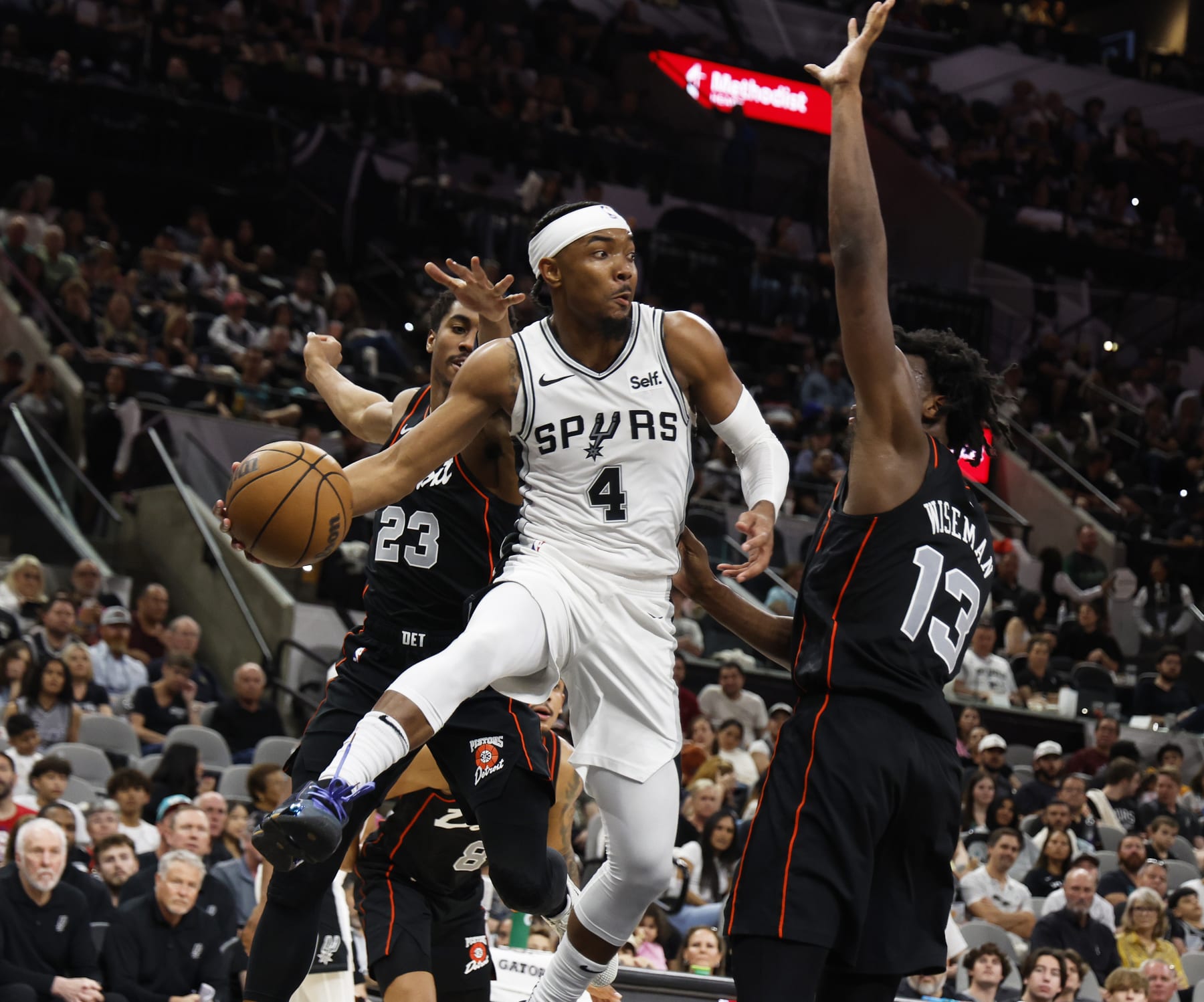 SAN ANTONIO, TX - APRIL 14:  Devonte Graham #4 of the San Antonio Spurs looks to pass around James Wiseman #13 of the Detroit Pistons in the second half at Frost Bank Center on April 14, 2024 in San Antonio, Texas. NOTE TO USER: User expressly acknowledges and agrees that, by downloading and or using this photograph, User is consenting to terms and conditions of the Getty Images License Agreement. (Photo by Ronald Cortes/Getty Images)