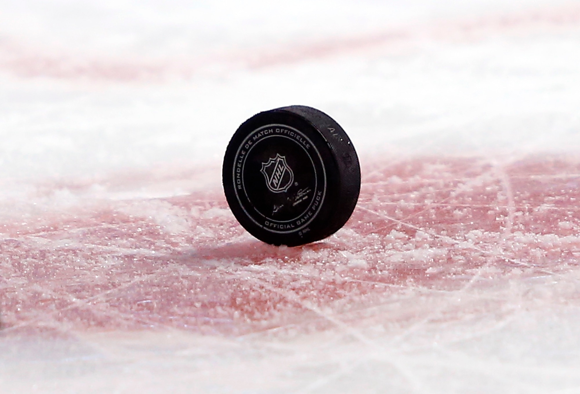 An official NHL hockey puck sits on a face off circle during the second period of an NHL hockey game between the Boston Bruins and the Buffalo Sabres in Boston Saturday, Feb. 6, 2016. (AP Photo/Winslow Townson)
