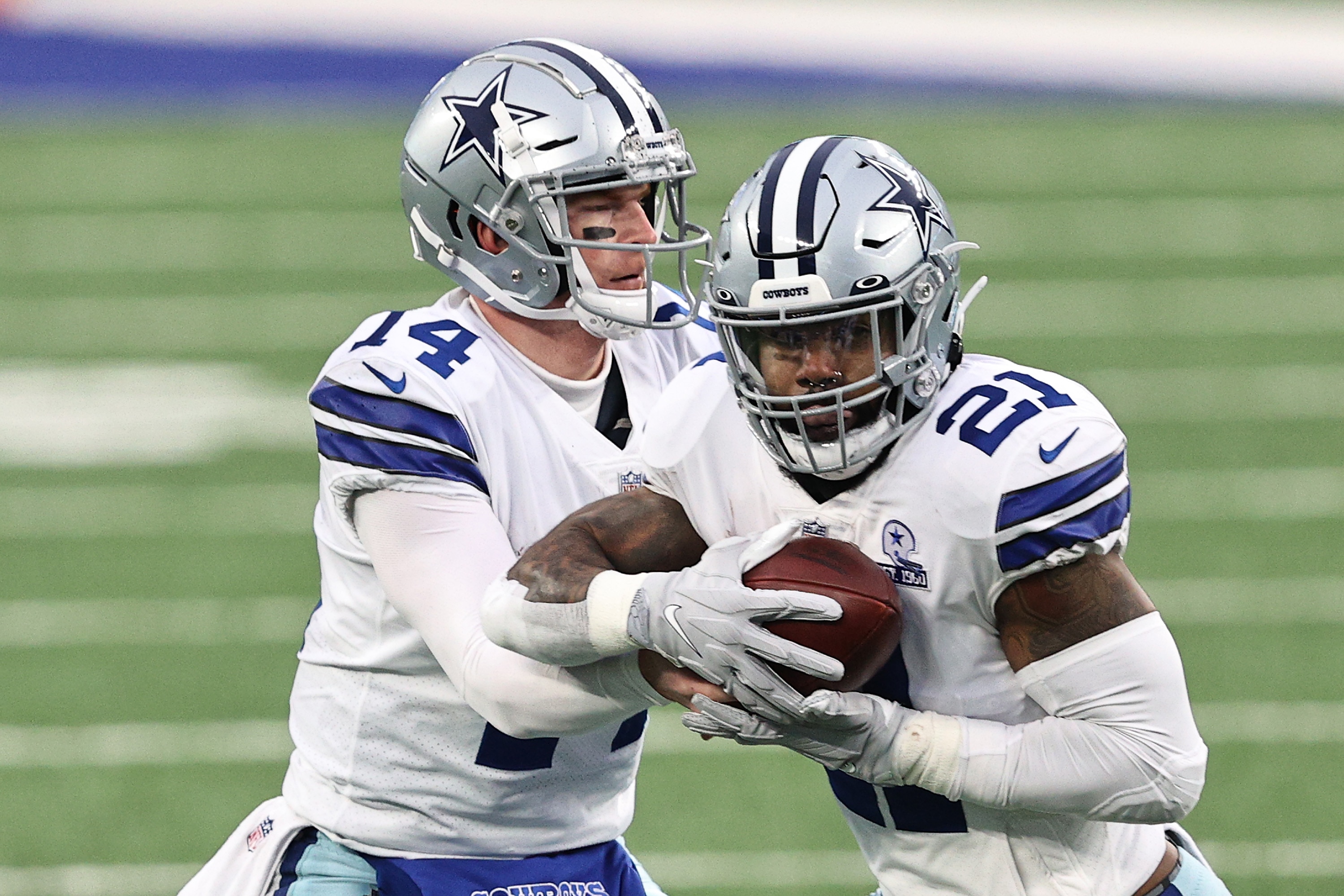 EAST RUTHERFORD, NEW JERSEY - JANUARY 03:  Ezekiel Elliott #21 takes the handoff from Andy Dalton #14 of the Dallas Cowboys during the second quarter against the New York Giants at MetLife Stadium on January 03, 2021 in East Rutherford, New Jersey. (Photo by Elsa/Getty Images)