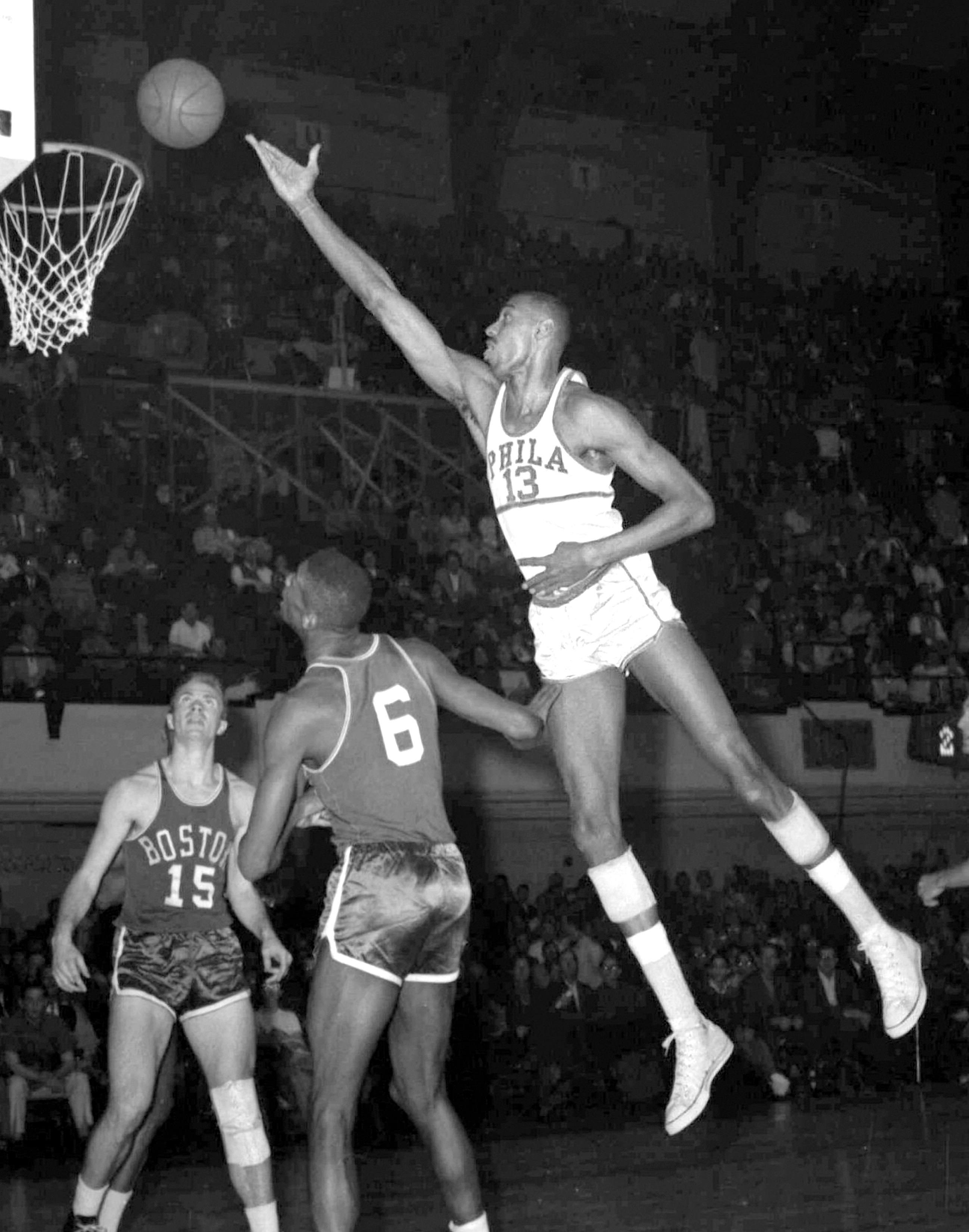 Wilt Chamberlain, of the Philadelphia Warriors, shoots over Boston defenders in Philadelphia, in this March 1960 file photo. Wilt the Stilt could become Wilt the Stamp if a grassroots effort to get the Hall of Famer and the only NBA player to score 100 points in a game on a commemorative U.S postage stamp is approved by postal officials. (AP Photo/files)