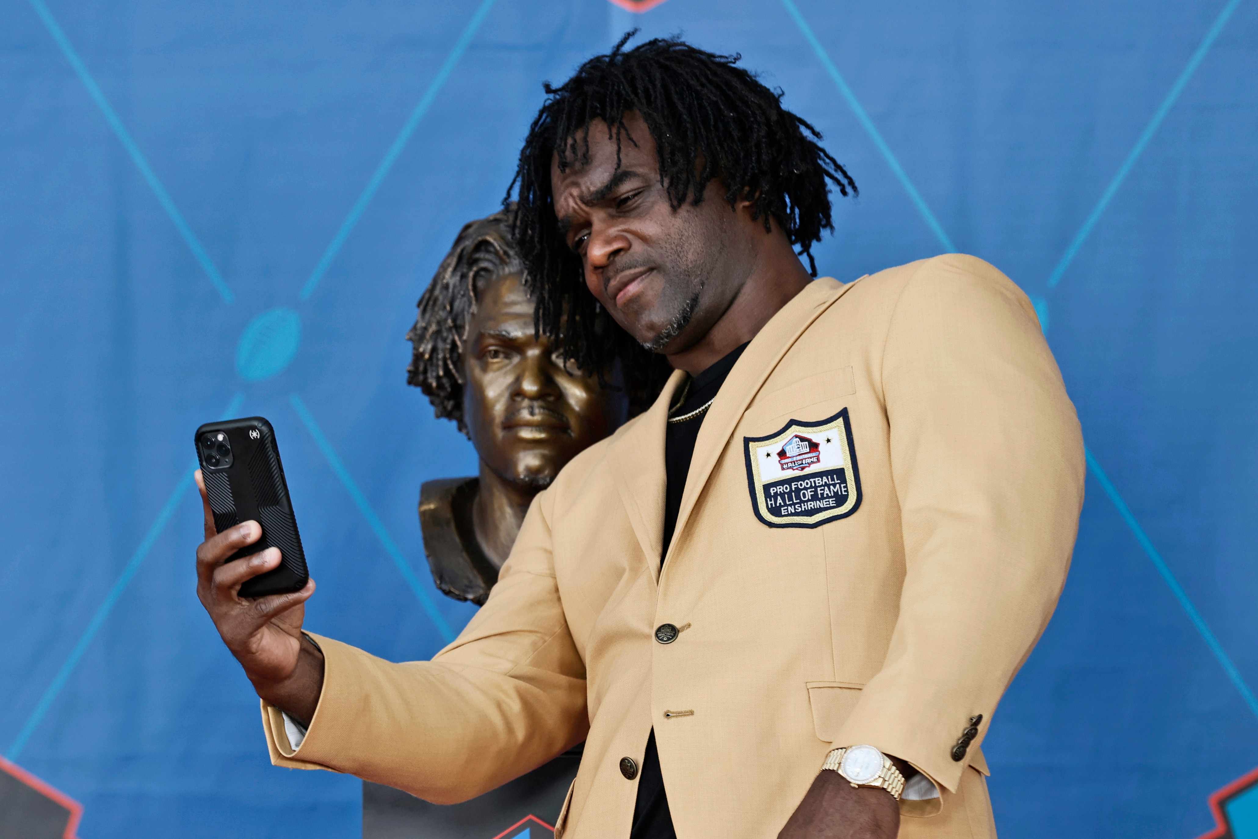 Edgerrin James, a member of the Pro Football Hall of Fame Centennial Class, takes a selfie with his bust during the induction ceremony at the Pro Football Hall of Fame, Saturday, Aug. 7, 2021, in Canton, Ohio. (AP Photo/Ron Schwane, Pool)